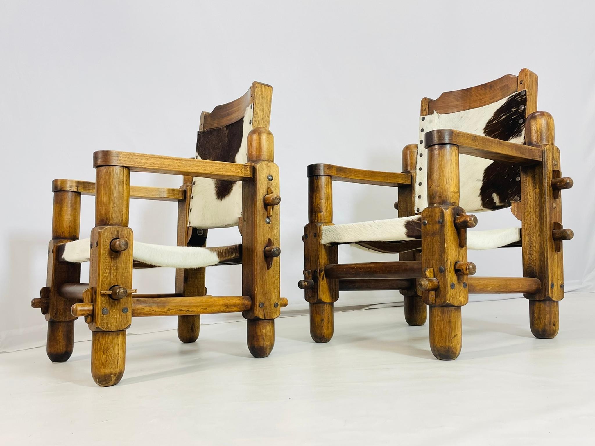 Paire de fauteuils vintage de style safari conçus et fabriqués au Brésil dans les années 1960.

Les chaises sont dotées d'un magnifique cadre en bois et sont revêtues d'une peau de vache.

Les pièces ne sont pas marquées.

Dimensions : 35,75 pouces