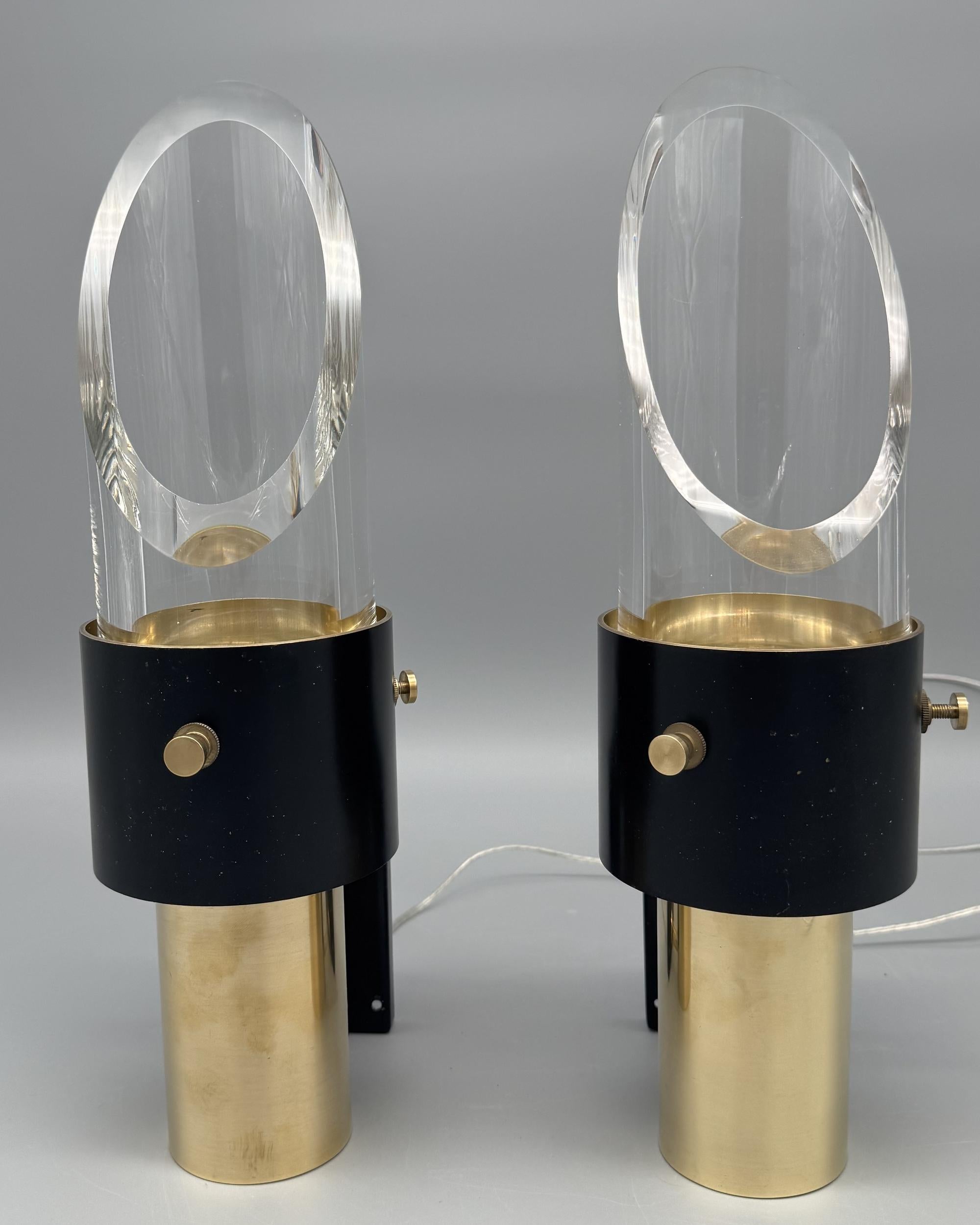 Pair of “Saga” sconces, designed by architect Kay Kørbing for Lyfa.
The base is in polished brass, the shade support in black lacquered brass and the shade in thick Orrefors glass.
They can be positioned either with the glass shade facing downwards