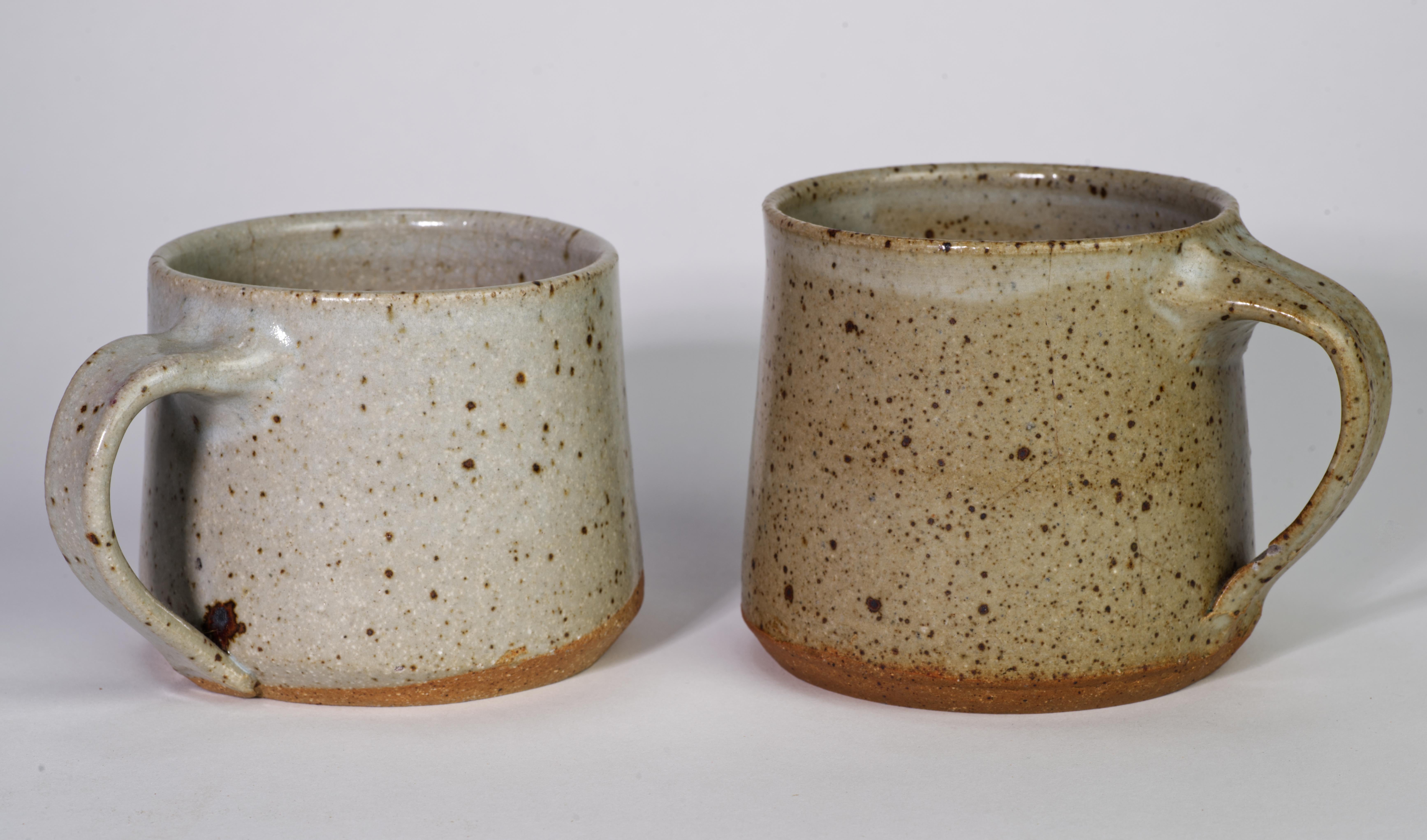  Des tasses ou des mugs inhabituels ont été jetés et émaillés à la main dans une glaçure au sel traditionnelle dans une palette gris-brun. Les surfaces intérieures des tasses sont décorées de figures féminines nues abstraites en relief qui seront