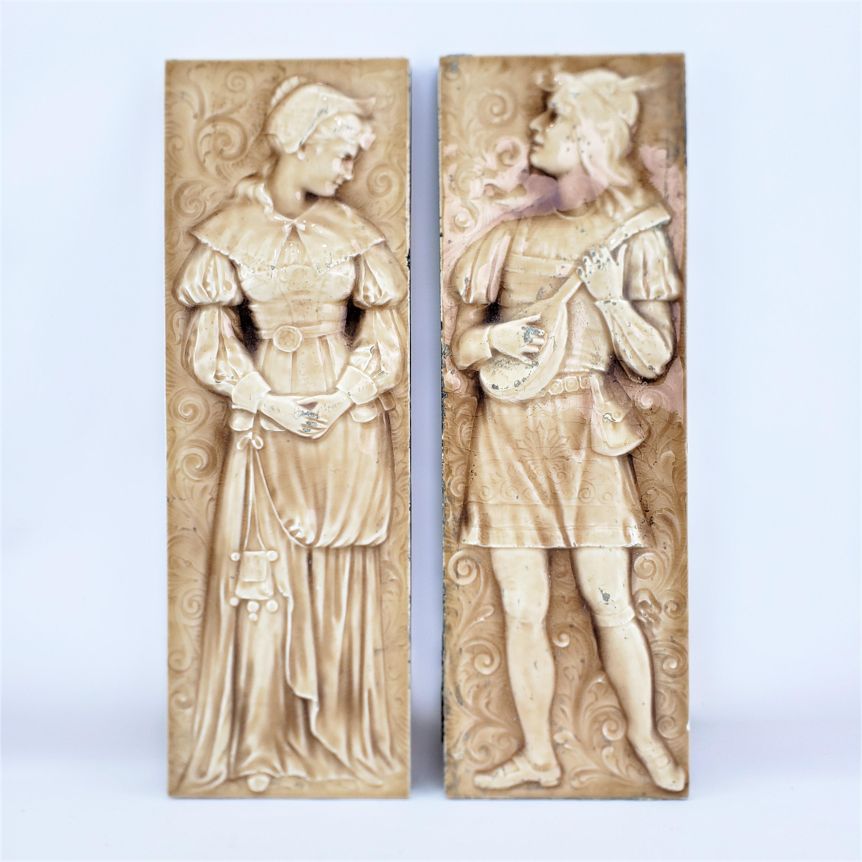 This pair of antique tiles are signed by the American Encaustic tile company of New York and date to approximately 1880 and done in a Renaissance Revival style. The tiles are composed of pottery that have been molded and glazed with a cream ground