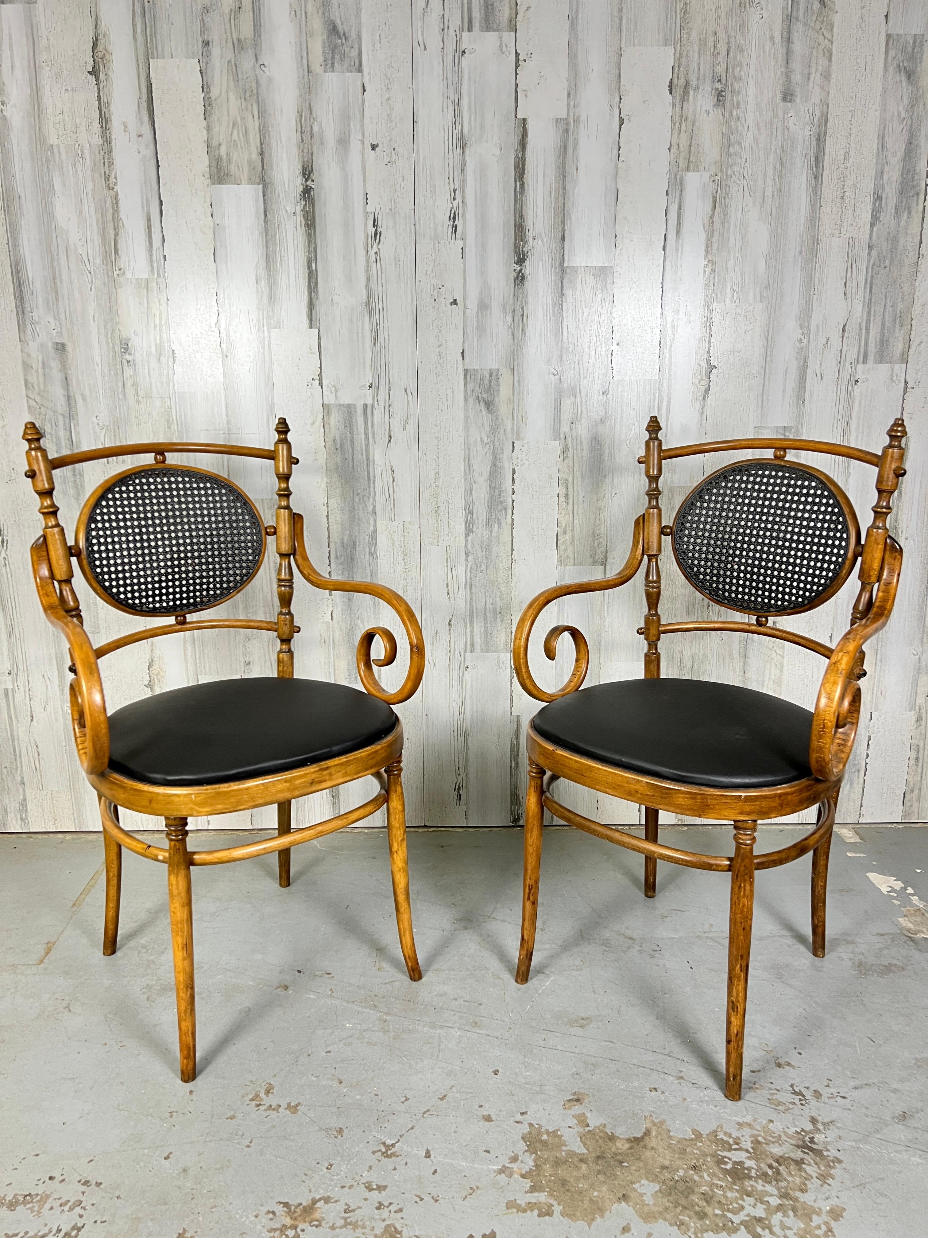Paire de fauteuils en bois courbé et en rotin fabriqués par Salvatore Leone pour Thonet à Modène, Italie. Rare paire de fauteuils de style transitionnel avec un dossier en bois tourné et des accoudoirs à volutes de style 
