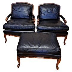 Pair of Sam Moore leather bergere-arm chairs with matching ottoman