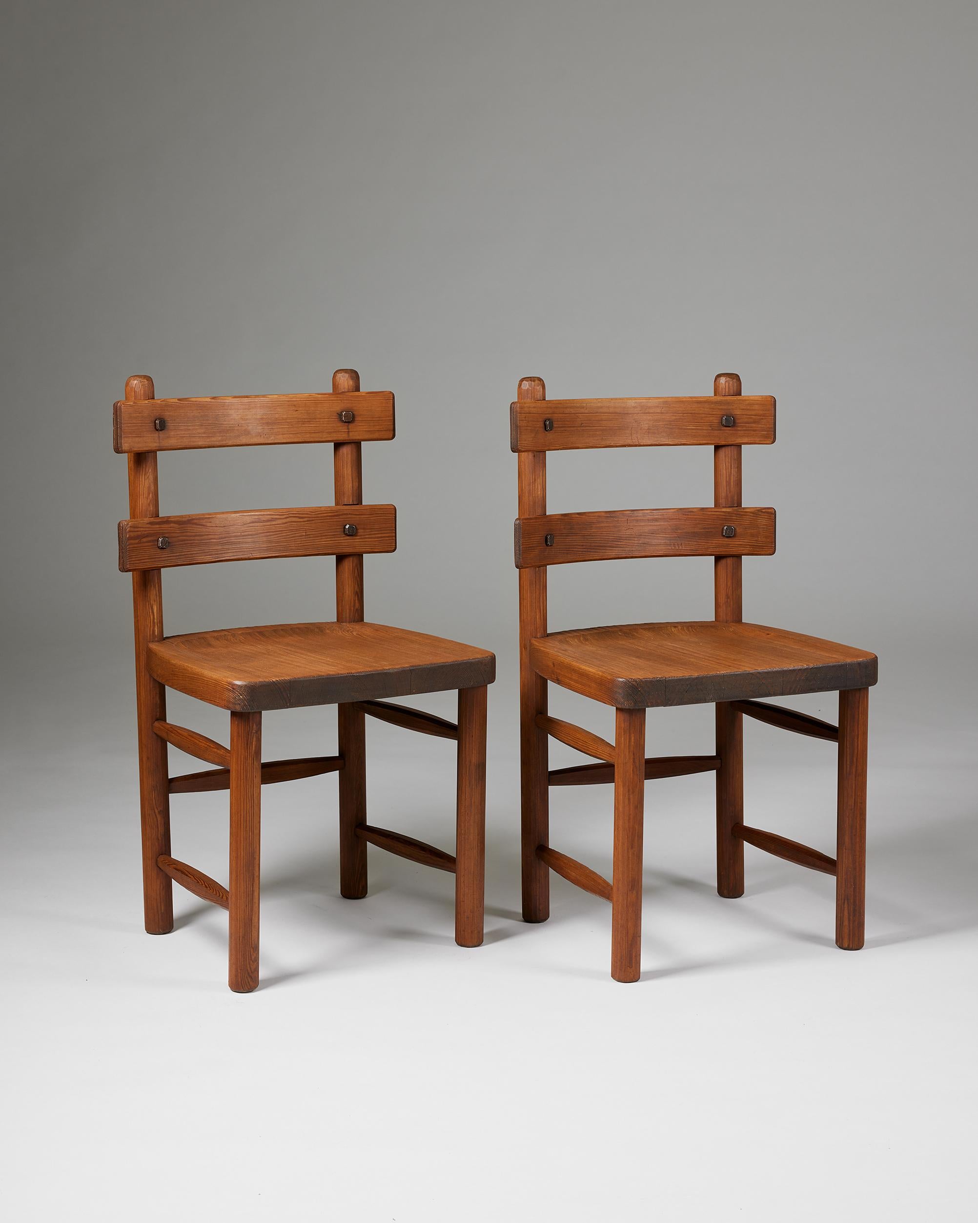 Pair of ‘Sandhamn’ chairs designed by Axel Einar Hjorth for Nordiska Kompaniet,
Sweden, 1932.

Hand-carved solid pine, and iron hardware.

Marked.

H: 86.5 cm / 2' 10''
W: 49.5 cm / 19 1/2''
D: 41 cm / 16''
SH: 45.5 cm / 18''