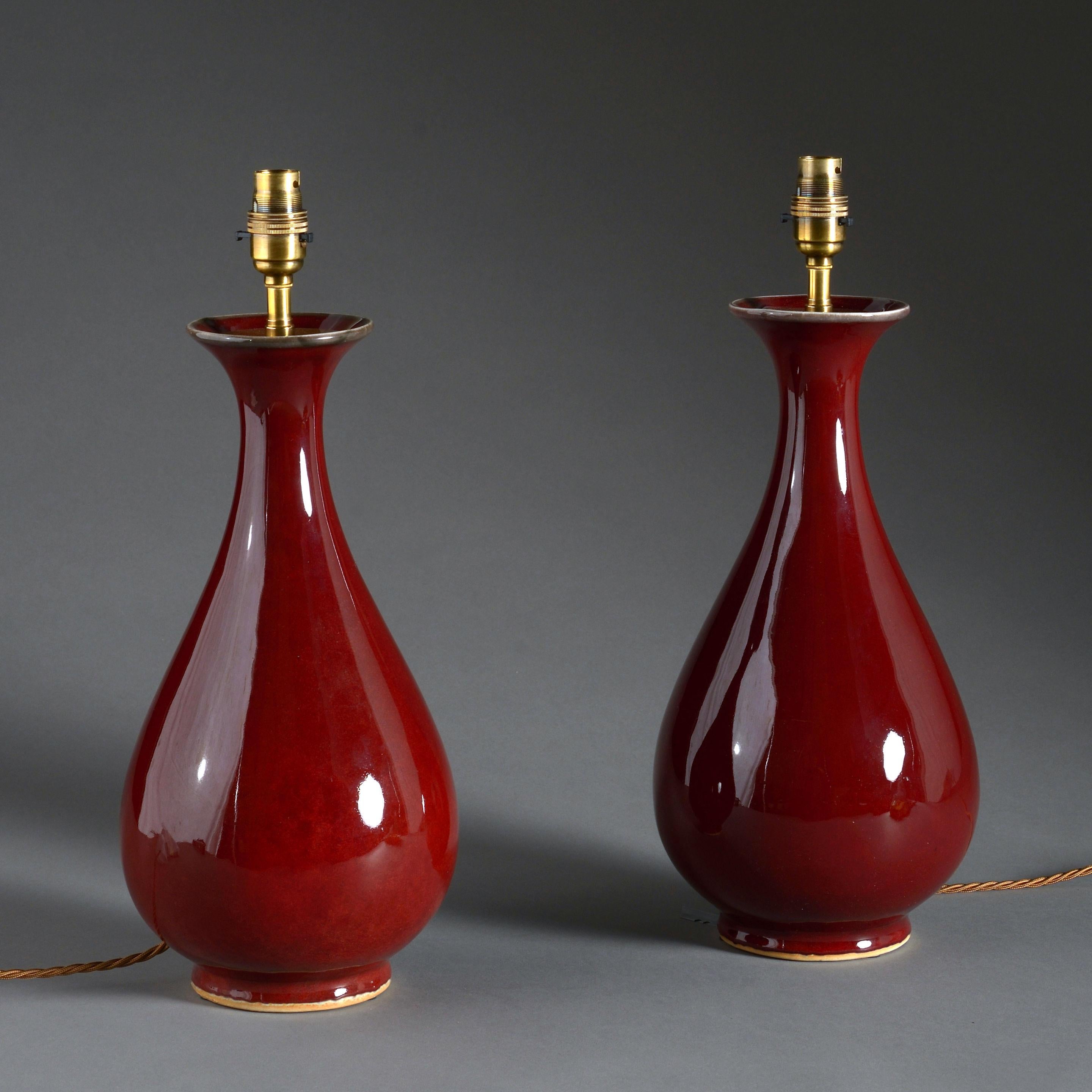 A pair of generously formed sang de boeuf porcelain vases now mounted as lamp bases.