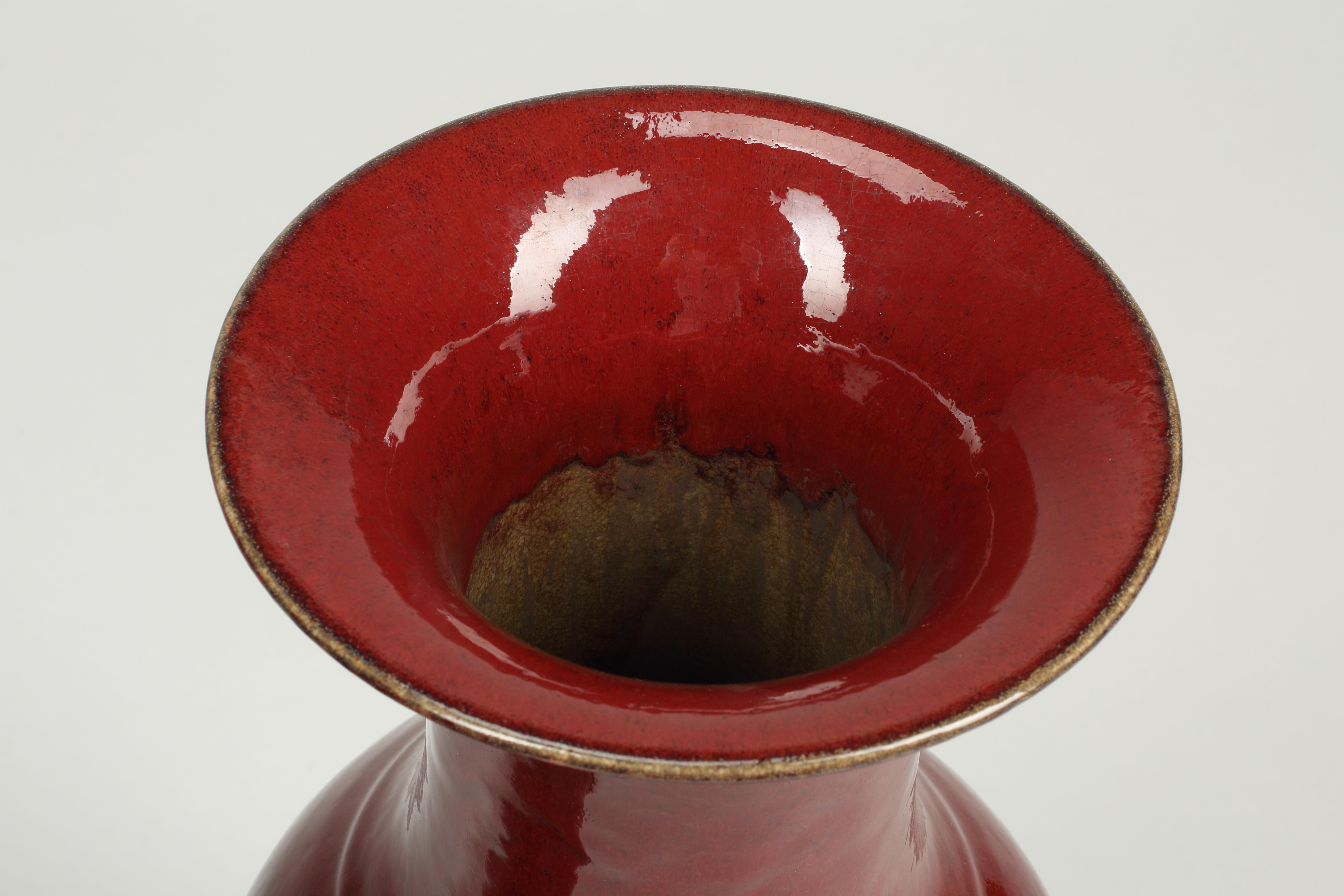 Ein hochdekoratives Paar großer glasierter Sang-de-Boeuf-Vasen, 20. Jahrhundert.
Das Balustergefäß steigt von einem Lippenfuß zu einem hochgeschulterten Körper und einer trompetenförmigen Mündung an und ist insgesamt mit einer reichen, glasig roten
