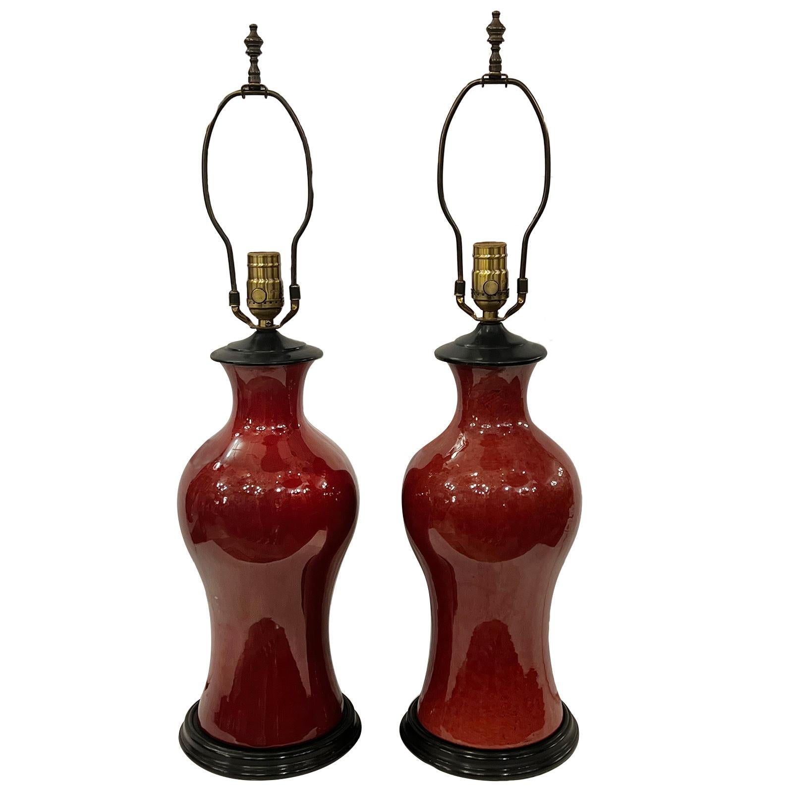 Pair of circa 1950's French sang de boeuf lamps with wood bases.

Measurements:
Height of body: 16.5