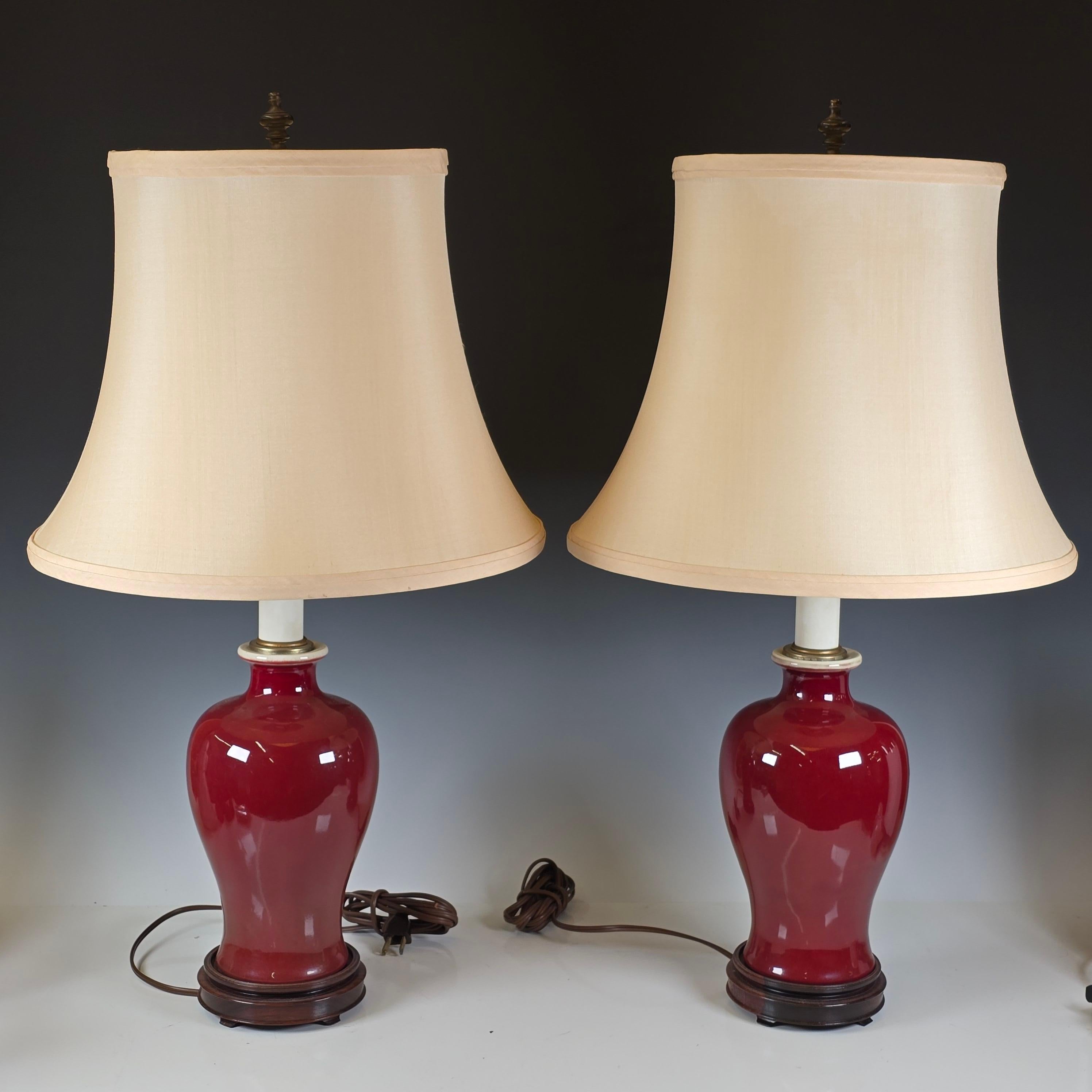 Paire de lampes Sang de Bœuf avec pied en bois de rose tourné à la main et abat-jour en soie.   Ils ont été achetés à New York dans un magasin d'antiquités et d'arts décoratifs haut de gamme dans les années 1990.  