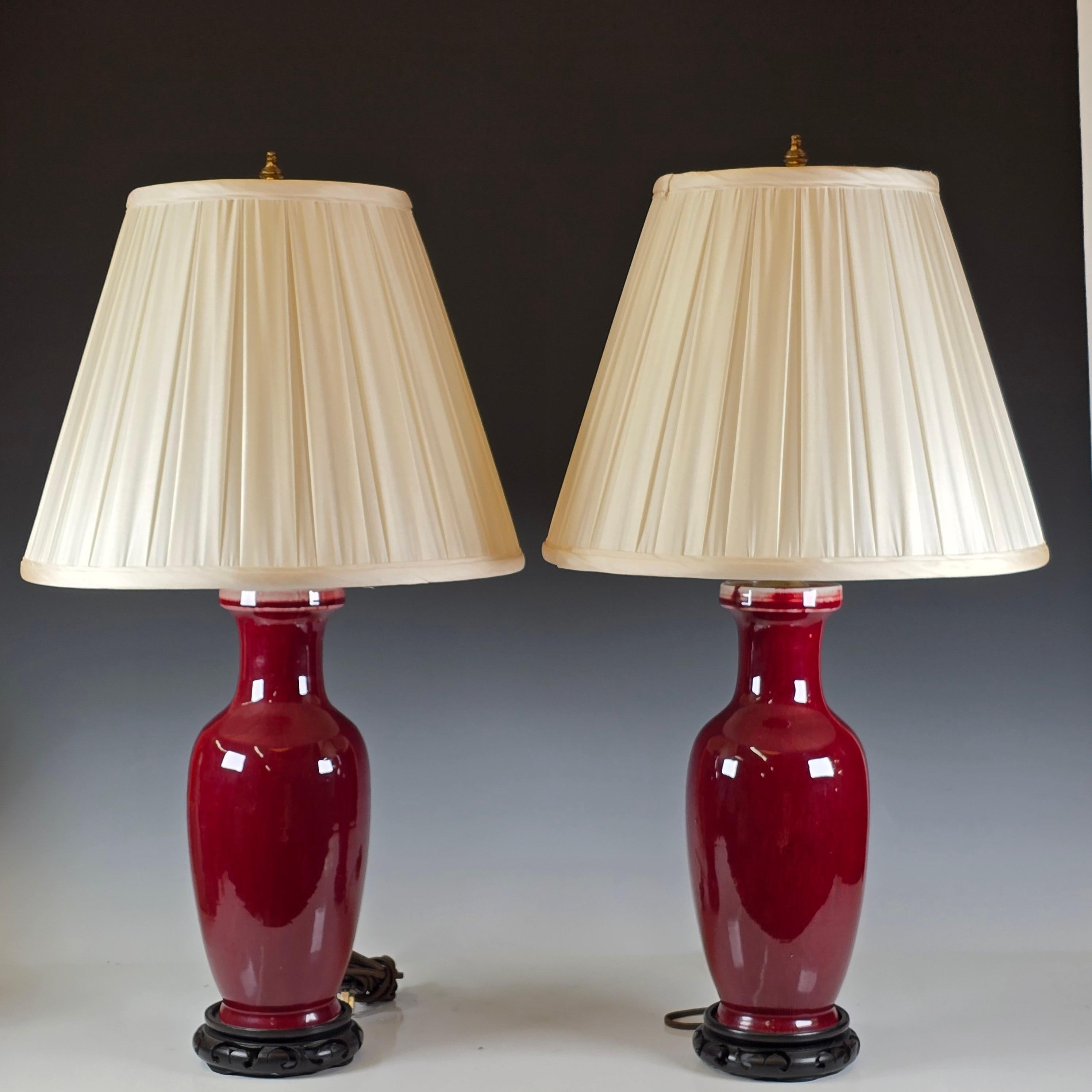 Stunning pair of Sang de boeuf lamps with silk shades and Rosewood stands.   Beautiful slight flambe look to the red.   Paired with a set of Beautiful box pleated silk lamp shades Naomi di Gavriel who owns a haute couture lamp shade shop in New York