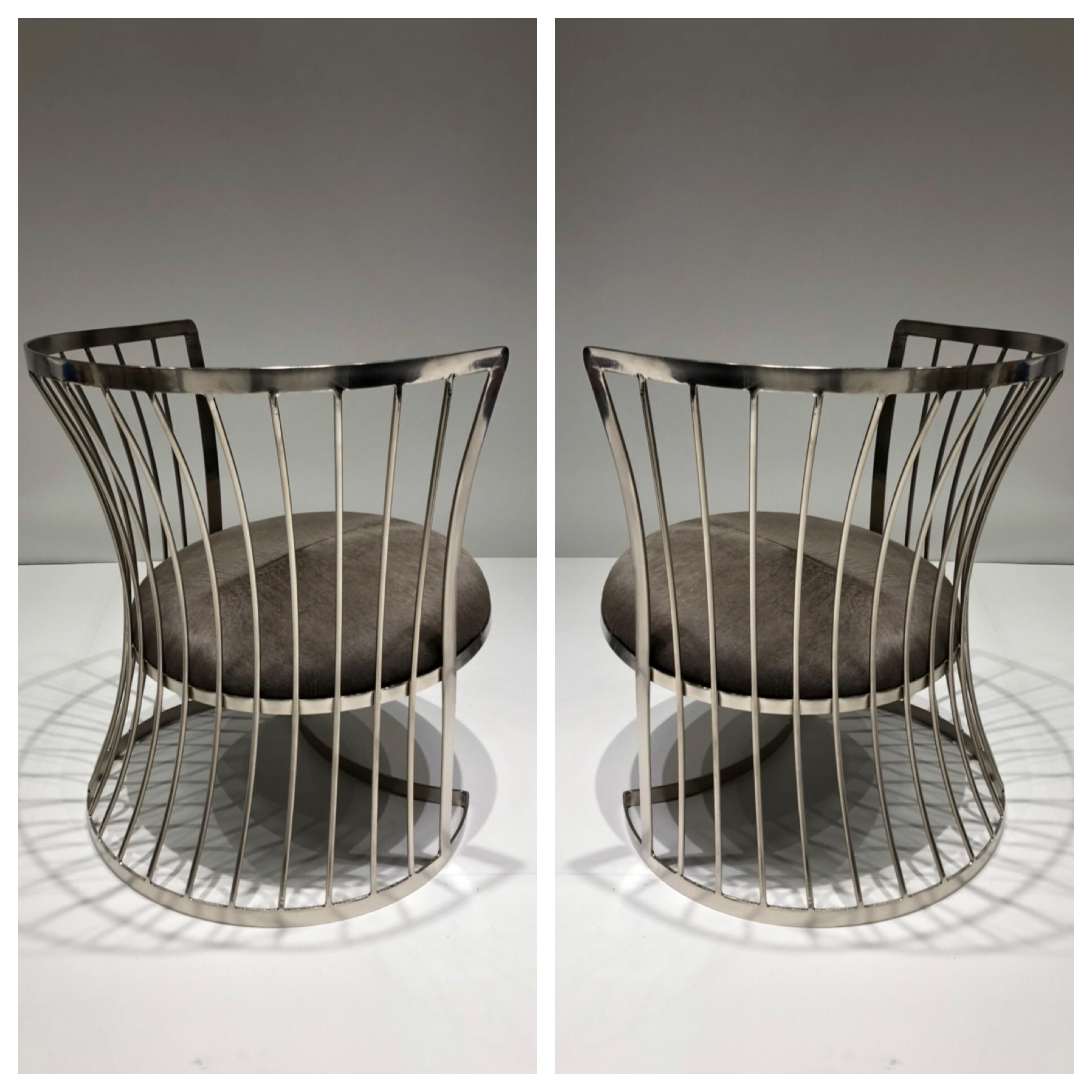 A glamorous pair of satin nickel lounge chairs, design in the 1960s by Russell Woodard. The chairs have been newly replated and the seats recovered in a gray cowhide.
Dimensions: 26.5” high 25” diameter 15” seat.