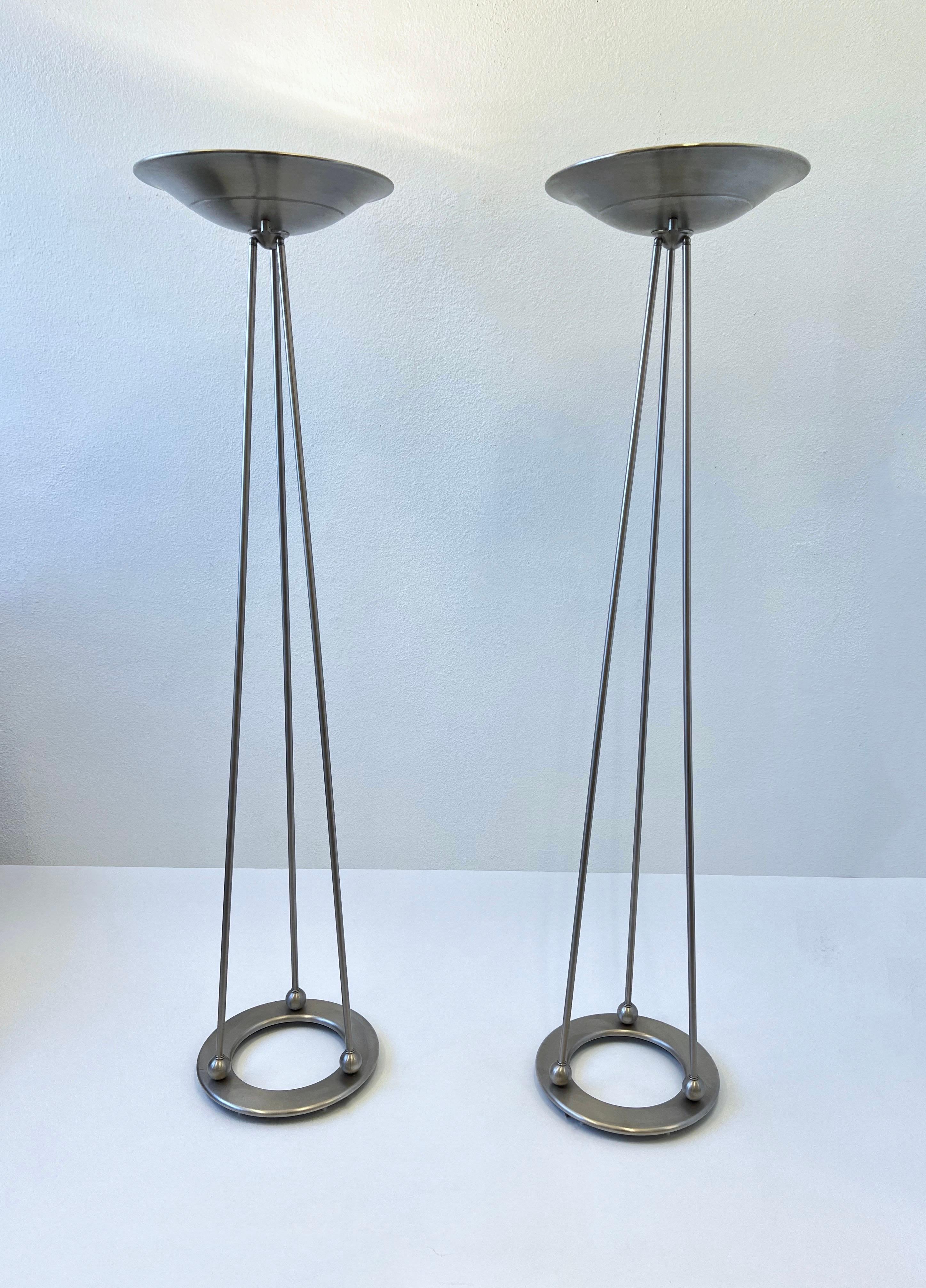 Pair of 1980s Satin Nickel “Olympiad Torchiere” Floor Lamps by Casella Lighting. 
In beautiful original vintage condition shows minor wear consistent with age. 
They have a full range control dimmer on the shade and take a 300w Halogen bulb.