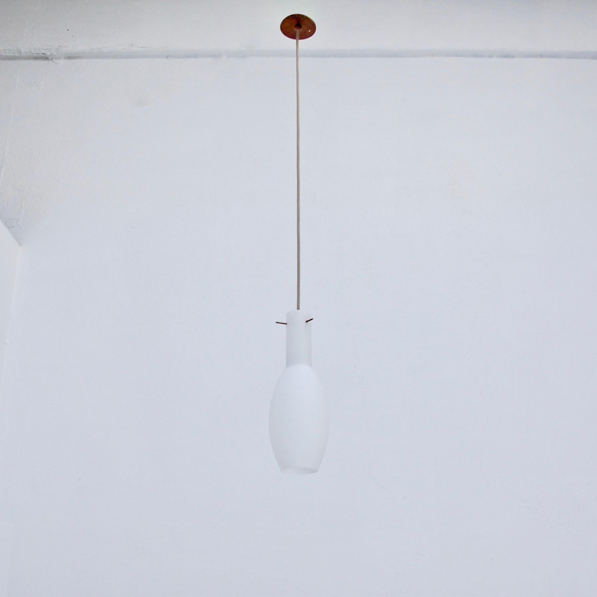 (2) Elegant narrow satin opal glass Italian pendants from 1950s Italy in glass and brass. Partially restored. Wired for use in the US with a single E26 medium based socket in each pendant. Light bulbs included in order. Overall drop adjustable upon