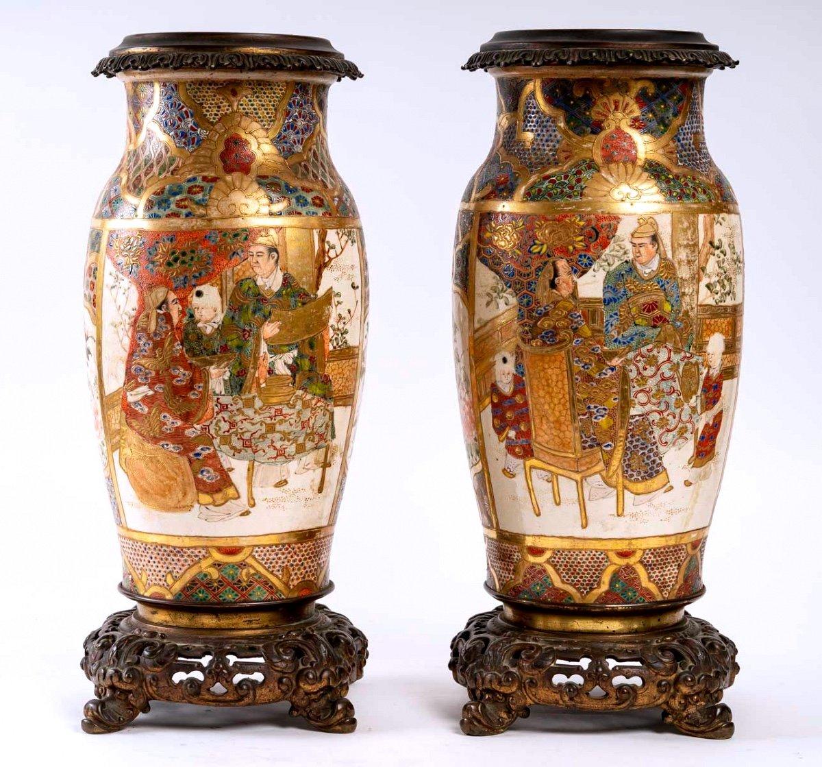 Elegante paire de vases ovoïdes en céramique montés sur bronze français, décorés d'émaux polychromes en relief et d'or pur sur fond blanc.
Le corps est décoré de grands cartouches représentant de hauts dignitaires dans des intérieurs. 

Les