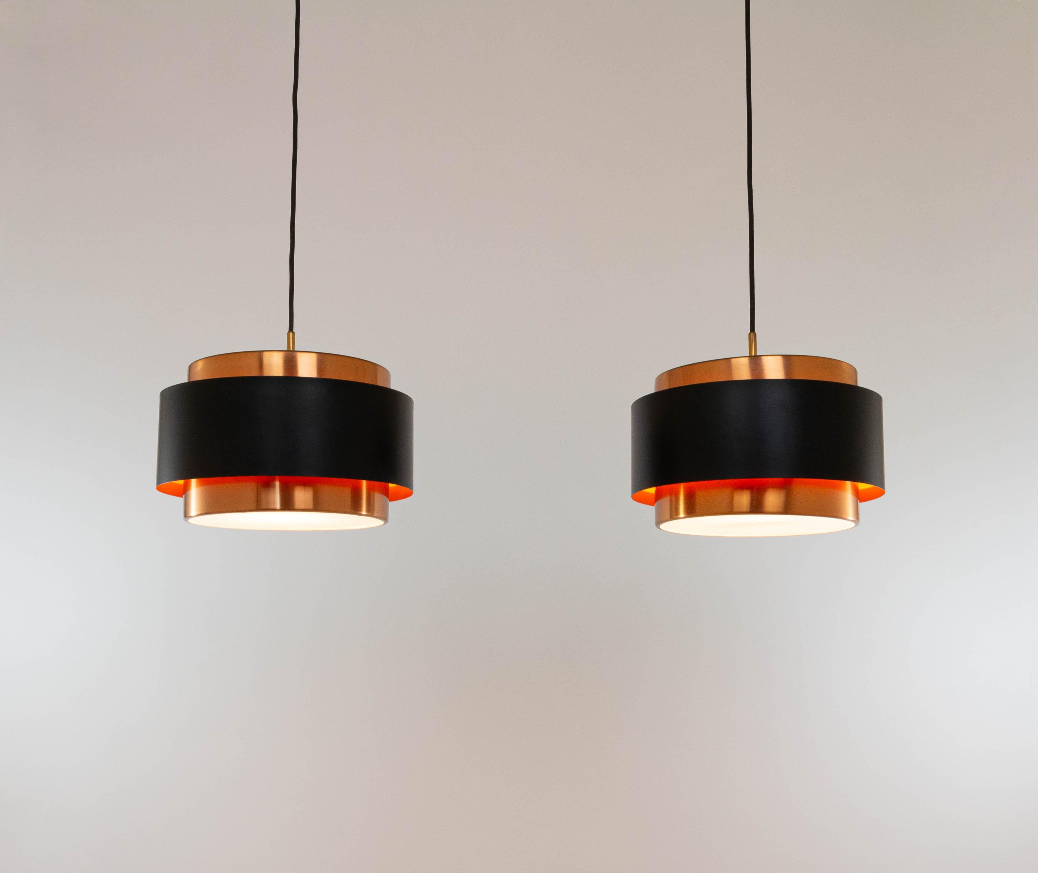 Two Saturn pendants, designed by Danish designer Jo Hammerborg and manufactured by Fog & Mørup.

The model is a structure of two concentric cylindrical copper bands that are held together by a black lacquered band. At the top and the bottom, the