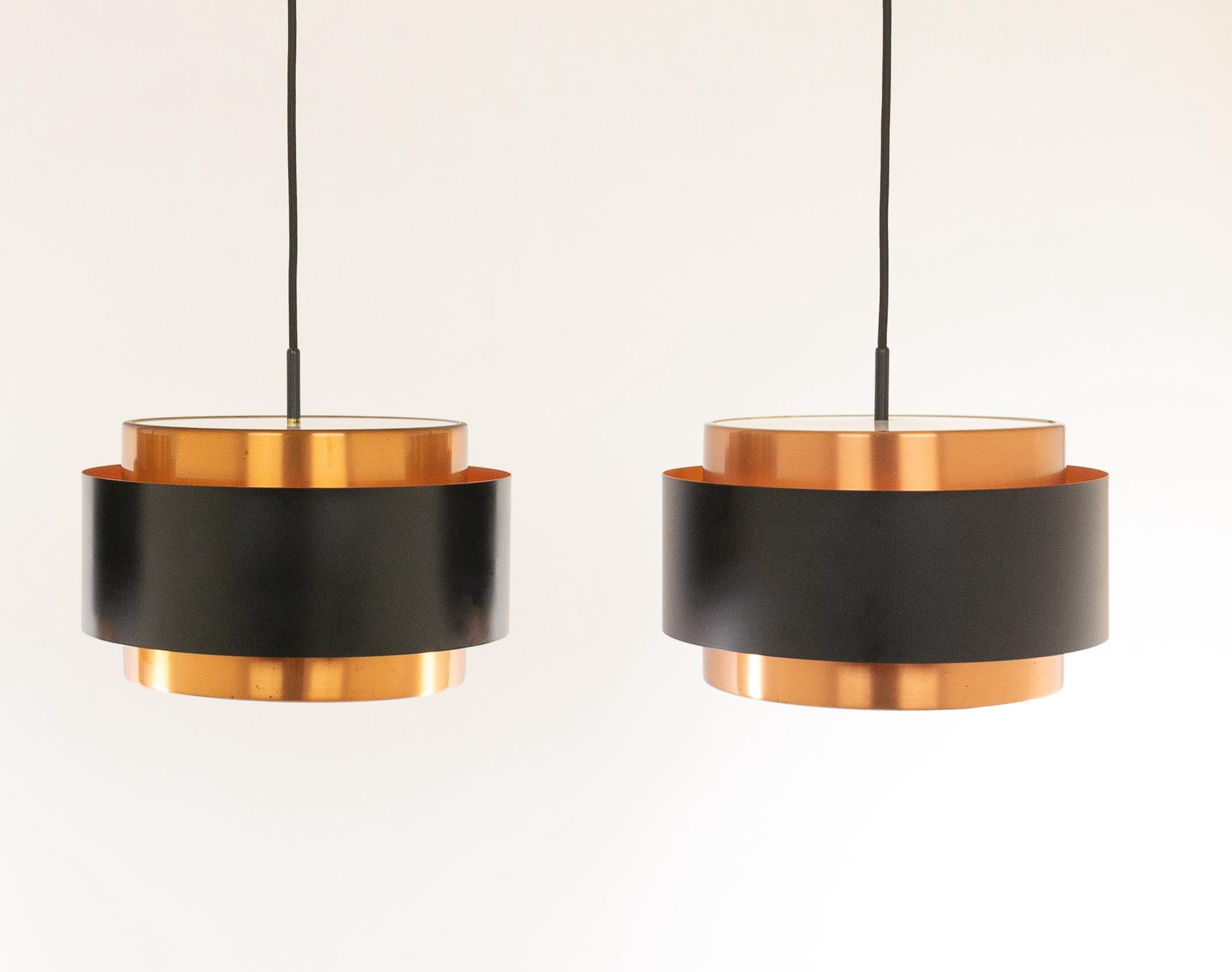 Zwei Saturn-Hängeleuchten, entworfen vom dänischen Designer Jo Hammerborg und hergestellt von Fog & Mørup.

Das Modell ist eine Struktur aus zwei konzentrischen zylindrischen Kupferbändern, die von einem schwarz lackierten Band zusammengehalten