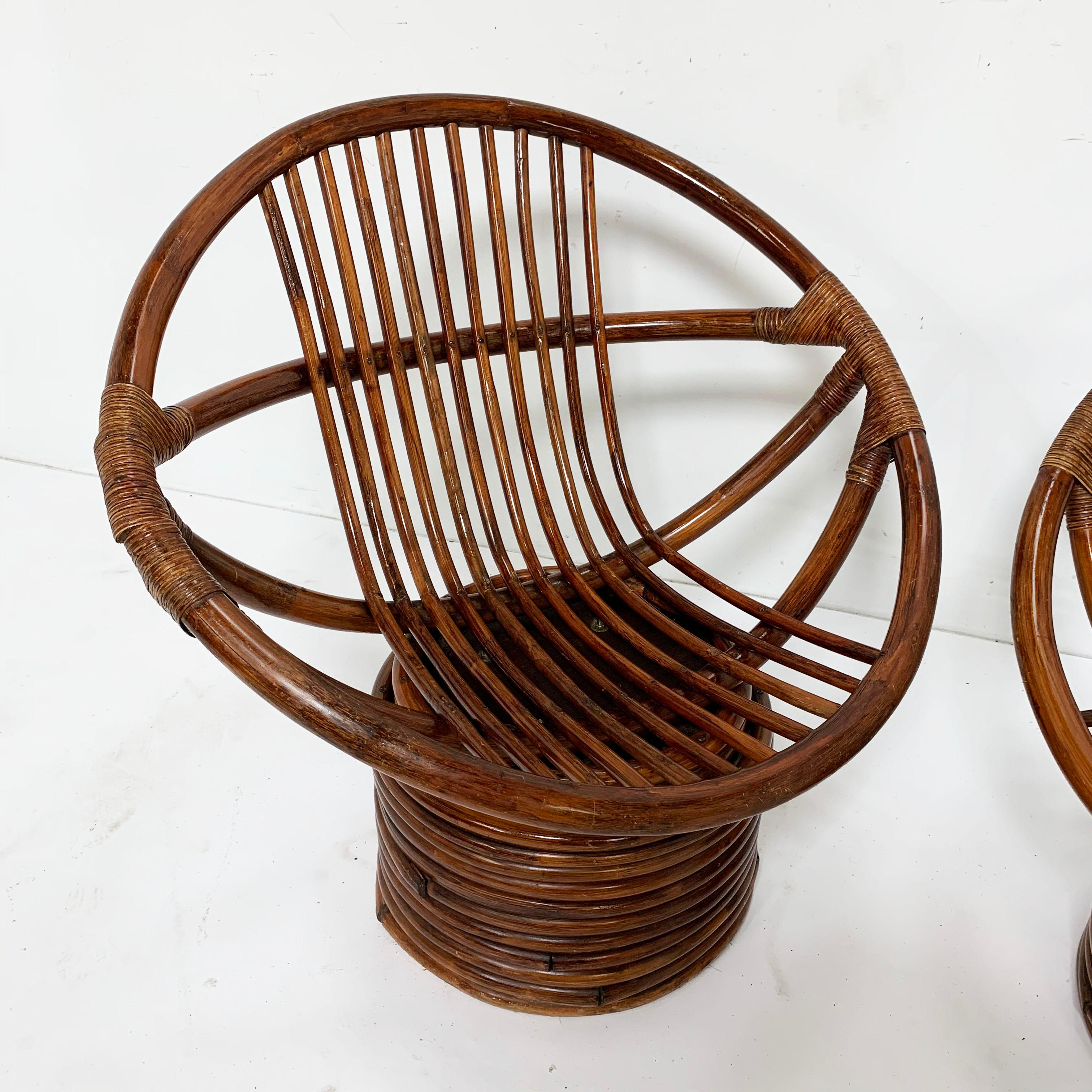 A pair of saucer-form swivel lounges in rattan, circa 1960s by Sun Products of Vernon, California. These vintage chairs have always resided safely indoors, and remain in excellent original condition. They’re extremely comfortable, even without seat