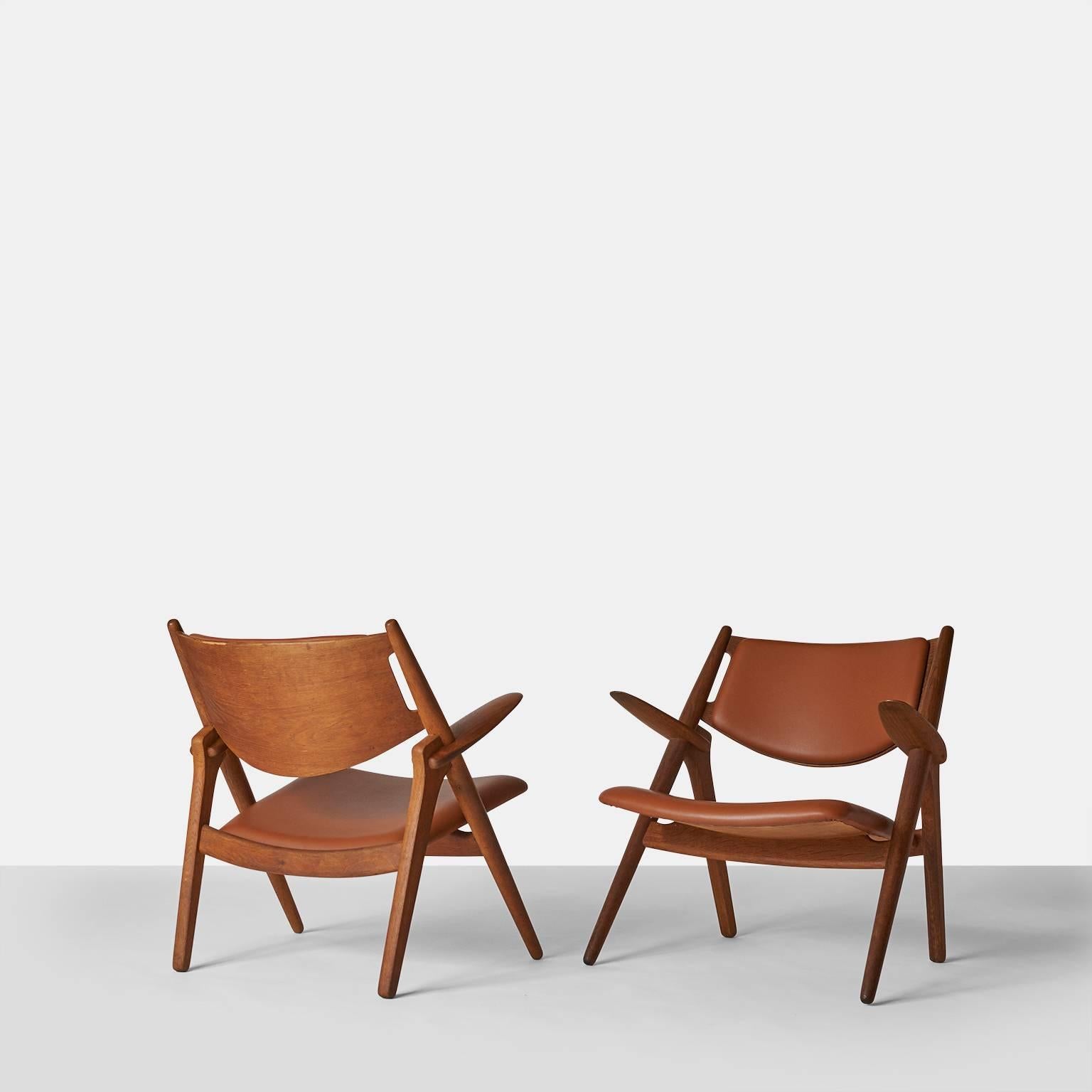 Pair of Sawbuck chairs, model CH-28 by Hans Wegner.
A pair of Sawbuck chairs produced by Carl Hansen & Son, made of oak and recently reupholstered in leather. 
Denmark, circa 1950s.