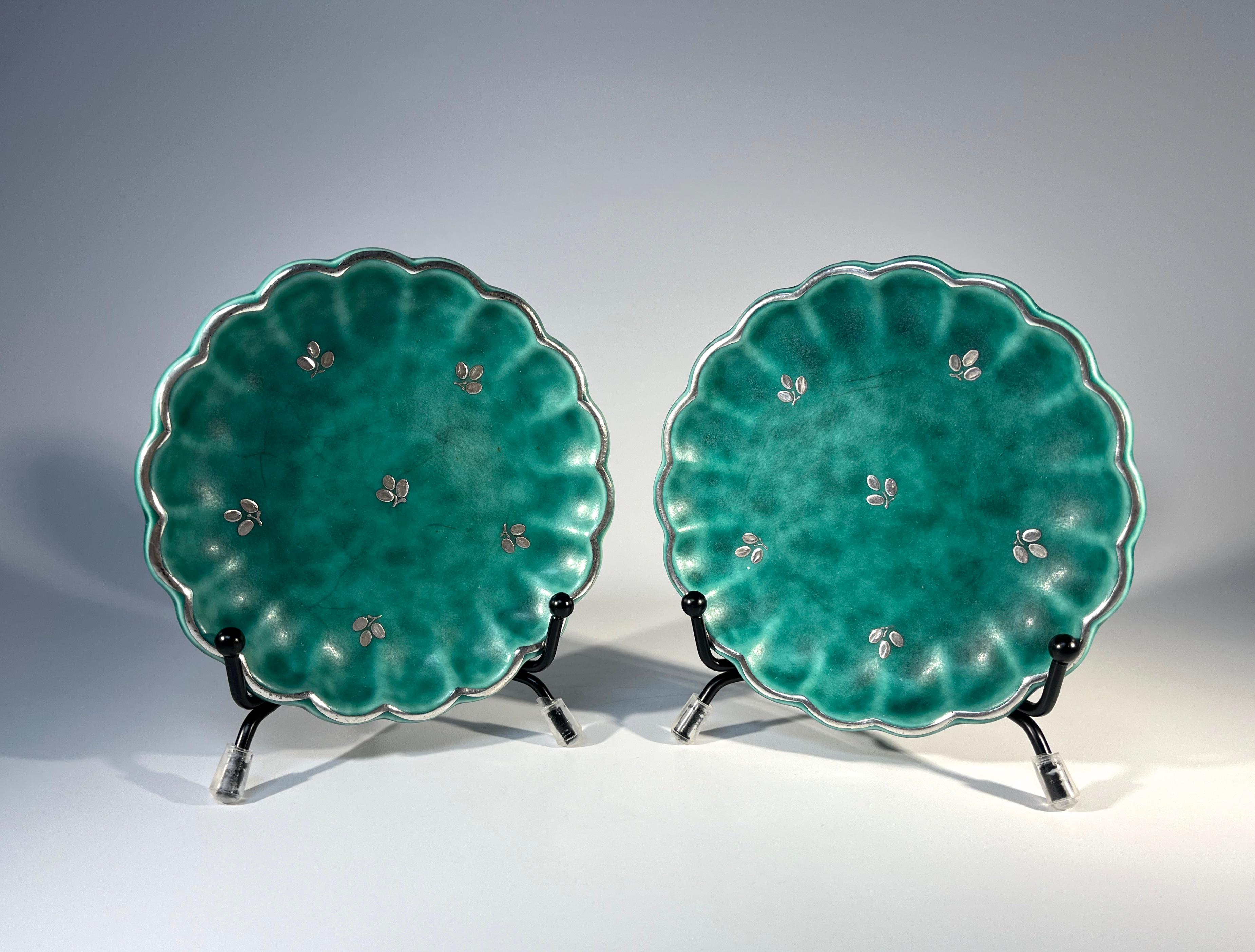 Delightful pair of scalloped edged stoneware pin trays by Wilhelm Kage for Gustavsberg, Sweden. 
Applied silver scalloped rim and trefoil flower sprigs decoration on signature Argenta green mottled stoneware
Circa 1960's
Stamped Gustavsberg Argenta
