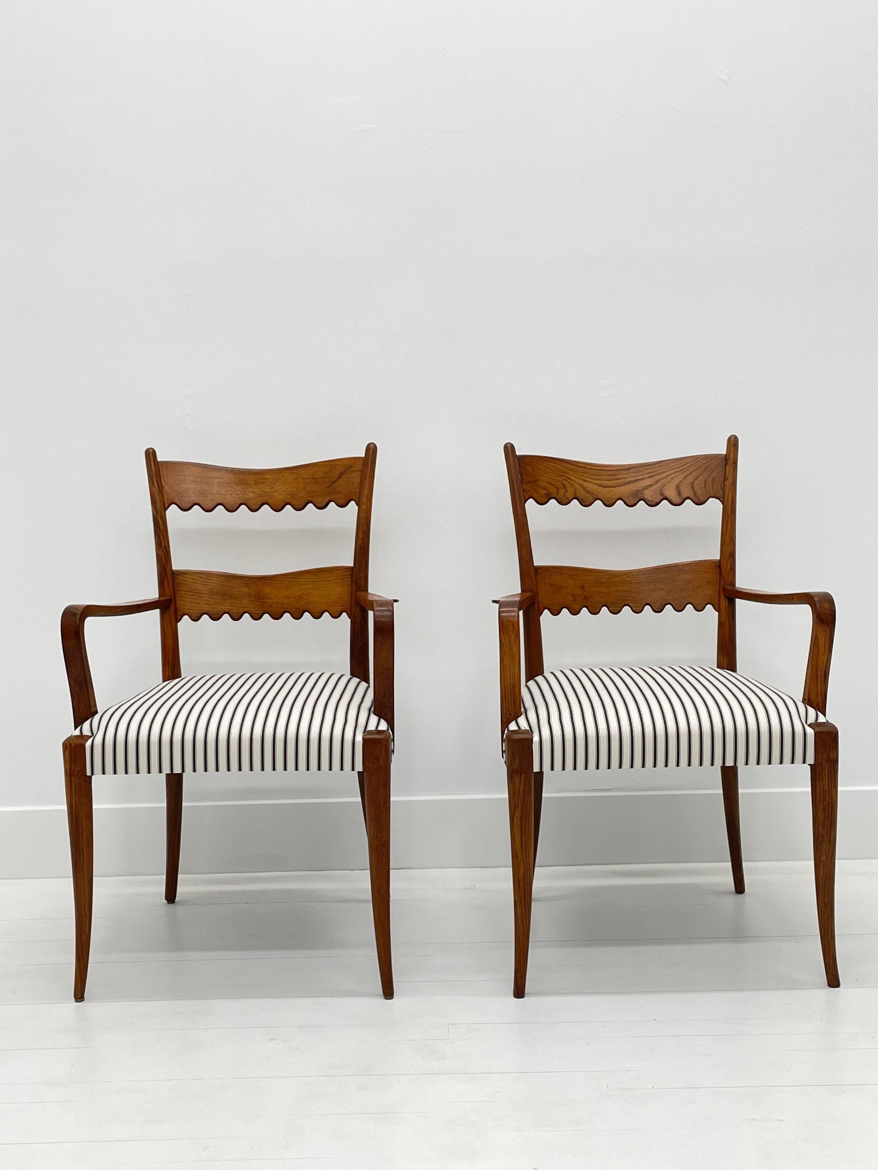 Set of two Scallop backed armchairs in Chestnut wood, Italy, 1940's. Attributed to Paolo Buffa. 

The lines of these chairs are masterful— the whimsical scalloped backs are beautifully proportioned and rendered. The graceful notched arms add to