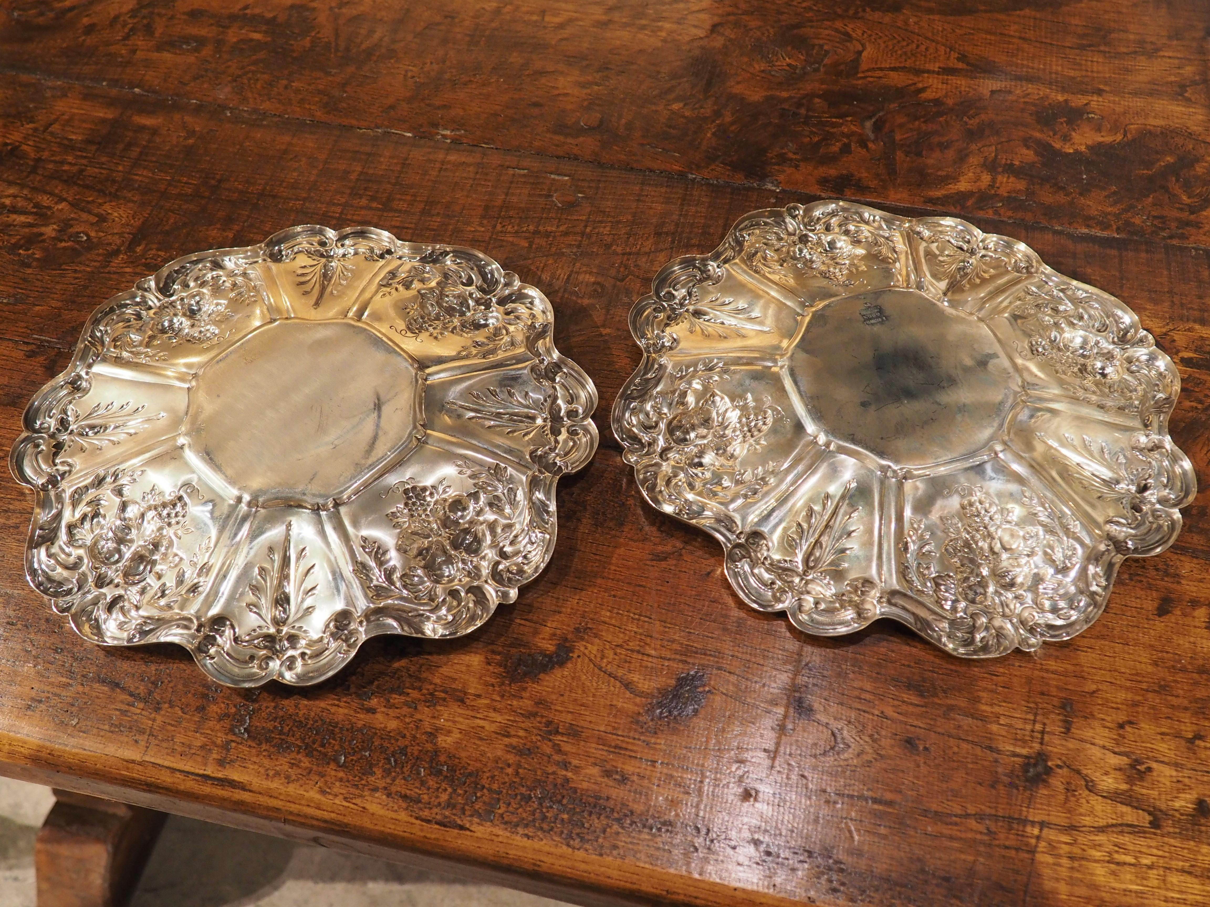 First produced in 1907 by the American silversmith company, Reed & Barton, this pair of sterling silver platters has repousse fruit motifs. Repousse is a metalwork technique where the verso (back) side is hammered to produce low relief images that