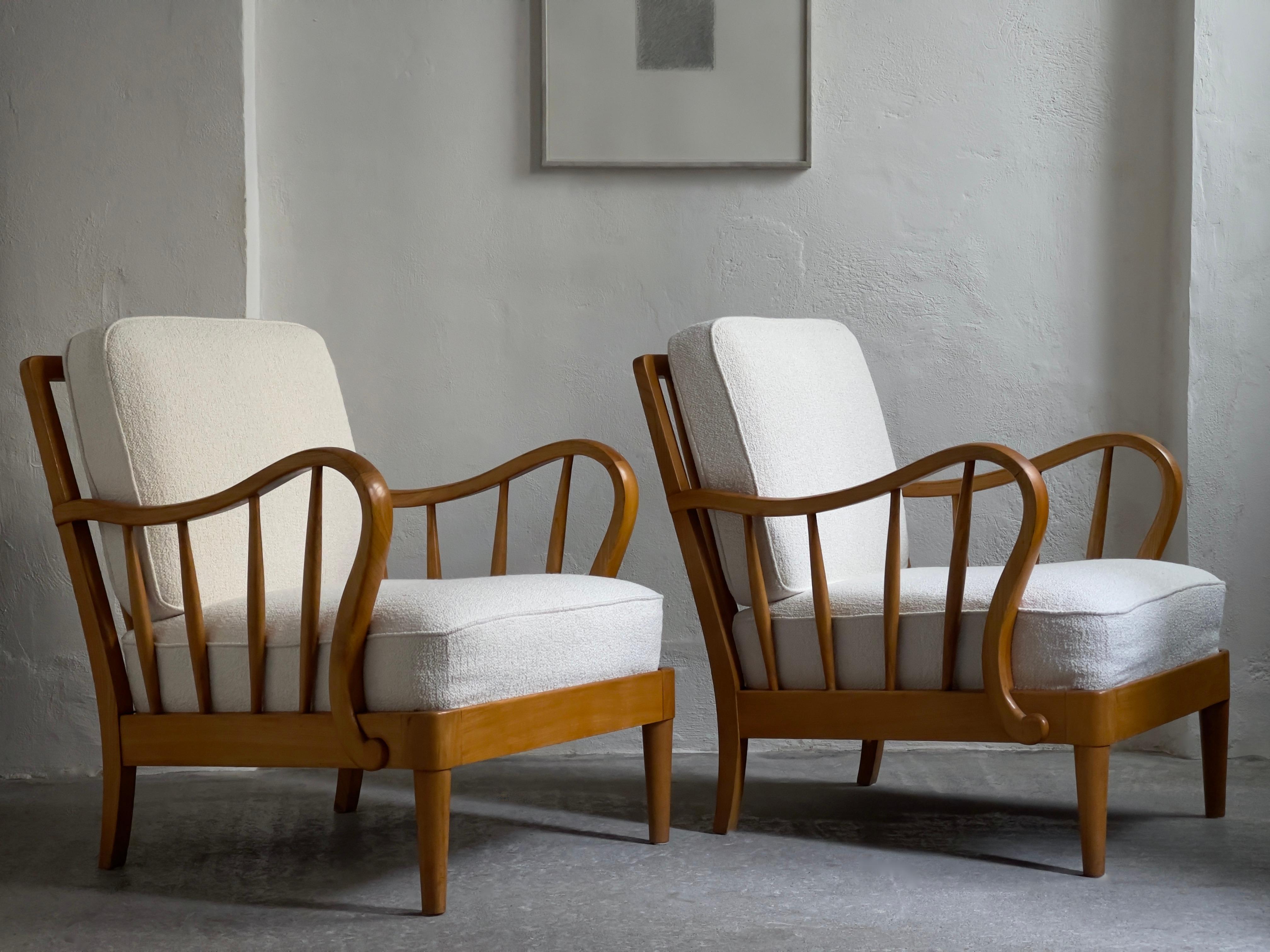 A rare and elegant pair of Danish cabinet maker lounge chairs crafted 1930s by  in rich patinated solid elm tree. The original cushions reupholstered in premium off white boucle.

Historical refinish to maintain a beautiful authentic grain and