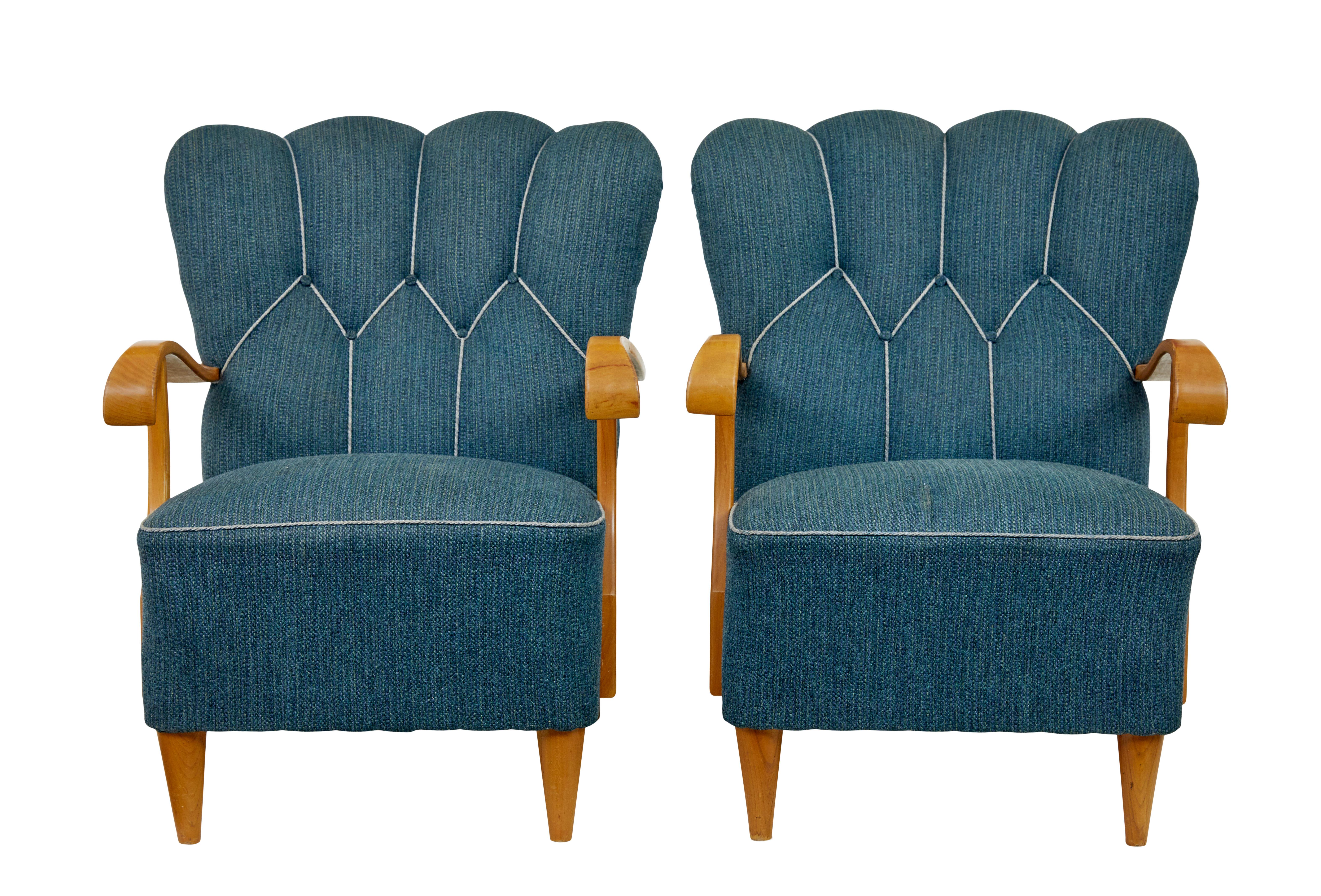 Good quality pair of Scandinavian designed armchairs circa 1950.

Shell shaped backs with contrasting piping.

Beech showframe exposed scrolling arms.  Standing on tapered legs.

Original upholstery with 1 repair to seat and some surface staining to
