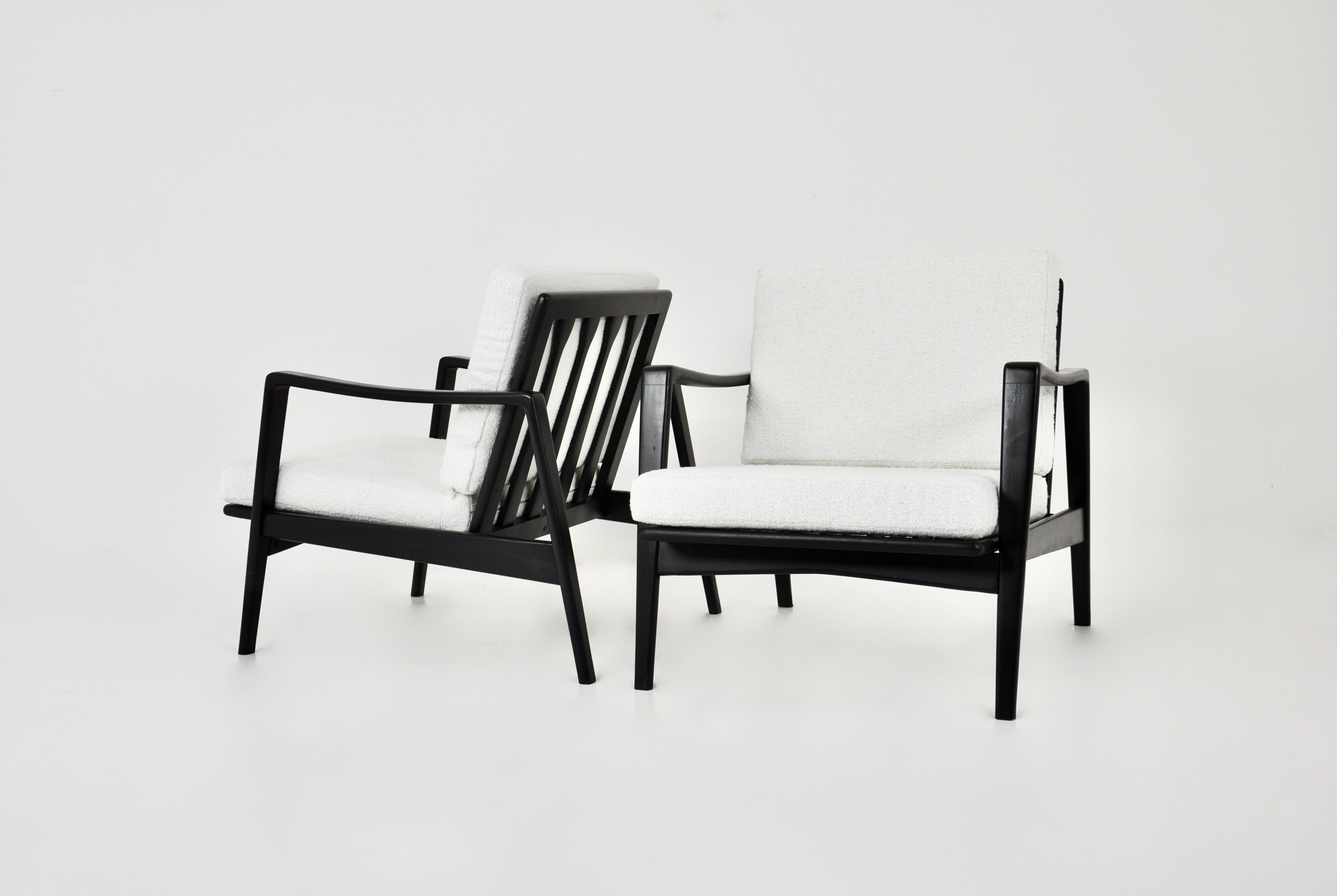 Paire de fauteuils en teck. Assise en mousse recouverte de tissu couleur vanille avec housse amovible. Dimensions : Hauteur de l'assise 38 cm. Légère usure due au temps et à l'utilisation des chaises.