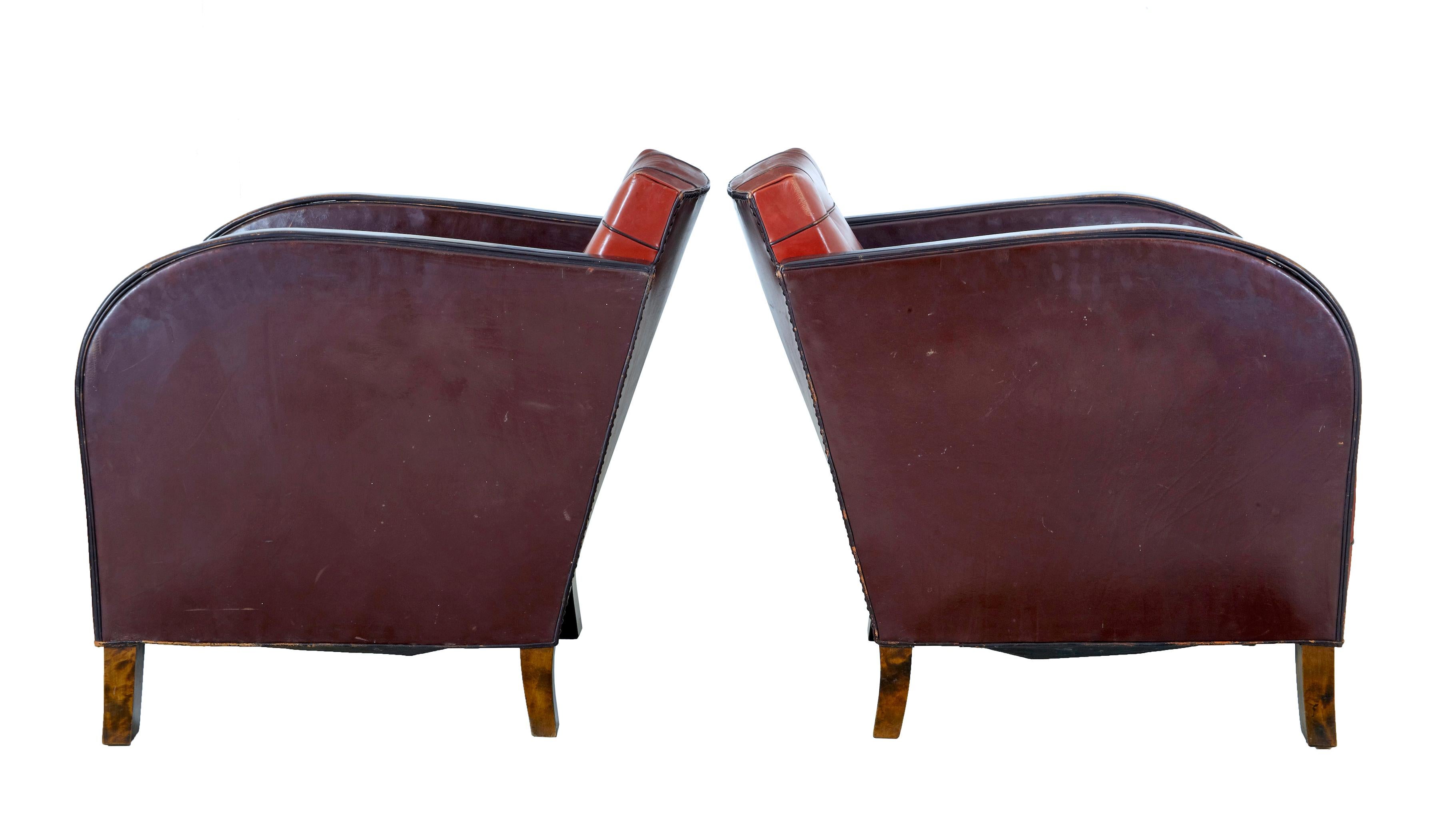 Pair of Art Deco leather club armchairs circa 1930.

Fine pair of elegant Art Deco armchairs with the typical flowing arms. Shaped backs. Upholstered in original red leather with piping and back buttons.

Standing on birch block feet.

Leather