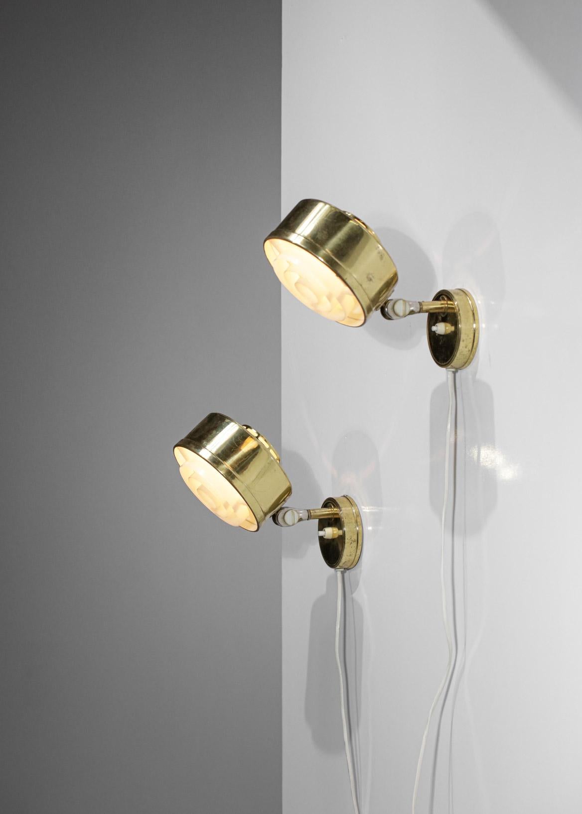 Pair of Scandinavian wall lamps from the 60's edited by the Swedish company ASEA. Round structure in solid brass and white plastic shade. Very nice vintage condition with slight traces of use (see pictures), wiring redone, recommended E26 bulbs.