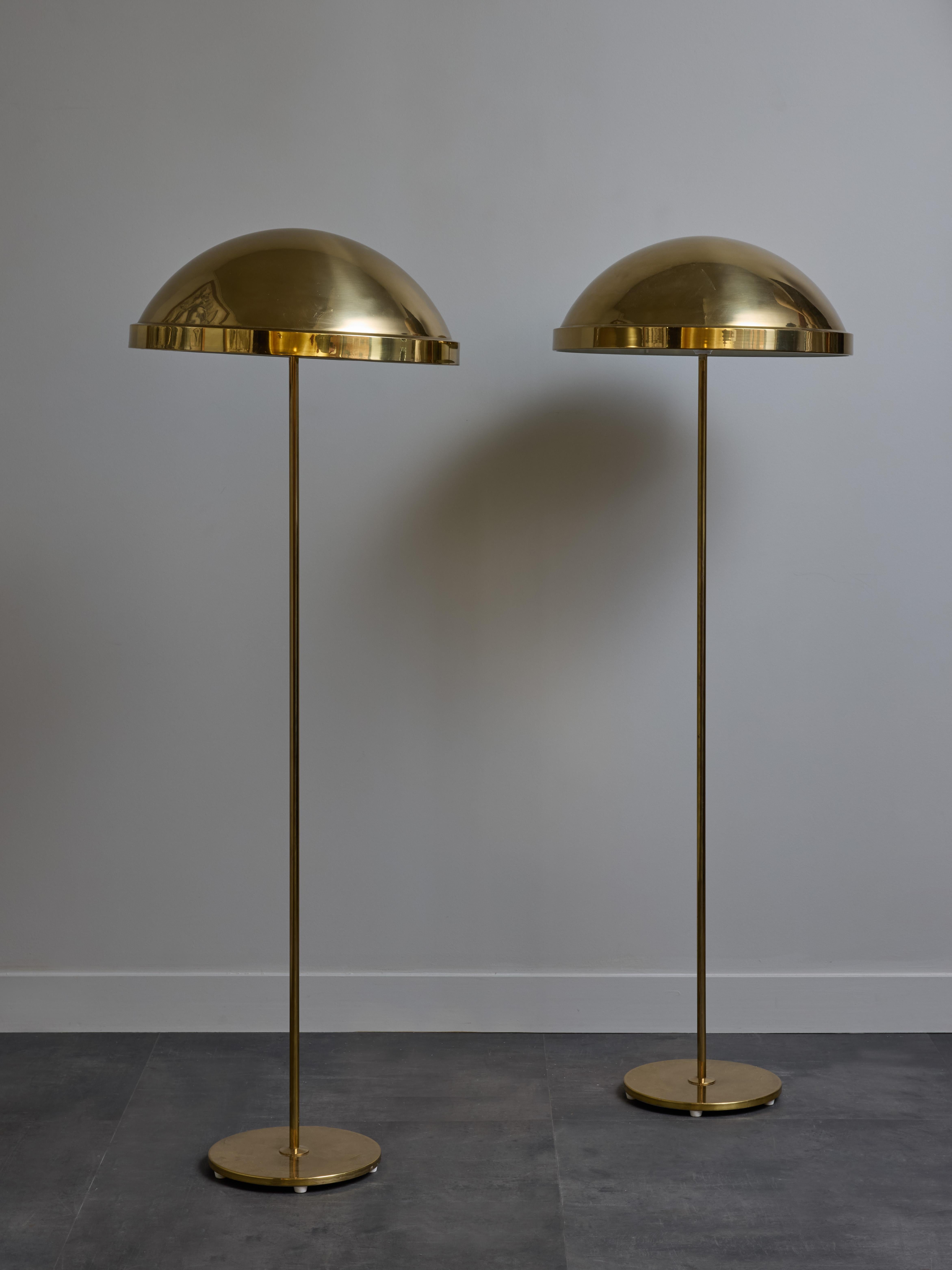 Paire de lampadaires en laiton raffinés, surmontés d'un abat-jour en forme de dôme.