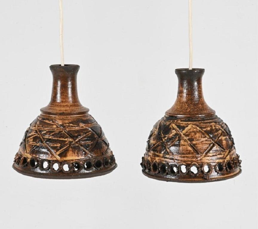 Coppia di lampade a sospensione moderne scandinave danesi in ceramica smaltata fatte a mano, circa 1960. Lo smalto marrone con fori presenta una presa per lampadina e un filo elettrico appeso. Devono essere cablati. 

Dimensioni: H. H. 8,25