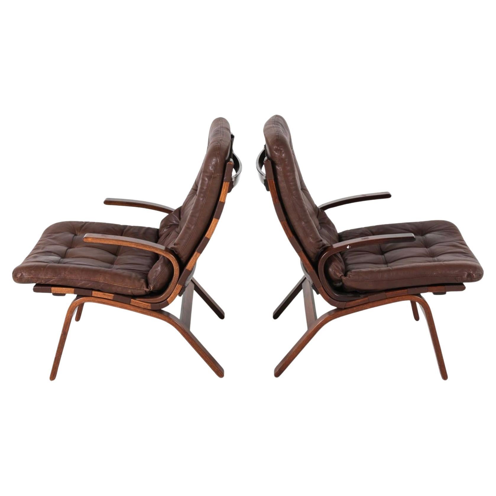 Paire de chaises de salon The Modern Scandinavian Brown Leather and Curved stained Beech wood. Dans le style d'Ingmar Relling. Cadre en bois courbé de Beeche marron foncé avec coussins en cuir marron foncé. Le cuir présente des signes d'utilisation