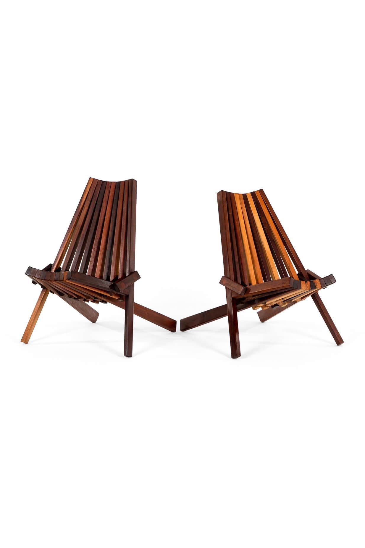 A striking pair of low profile folding chairs in teak perfect for both inside and outside use.

This original design pair of chairs are expertly constructed and very comfortable to sit in.

The chairs will add style to any setting they are placed