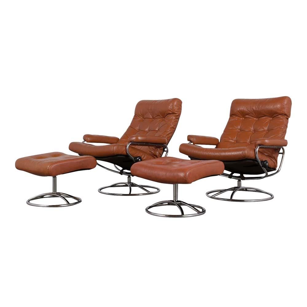 This pair of modern Scandinavian swivel reclining lounge chairs with matching ottomans has been completely restored. The set features a steel chrome-plated frame in very good condition and is upholstered in there original cognac color leather with