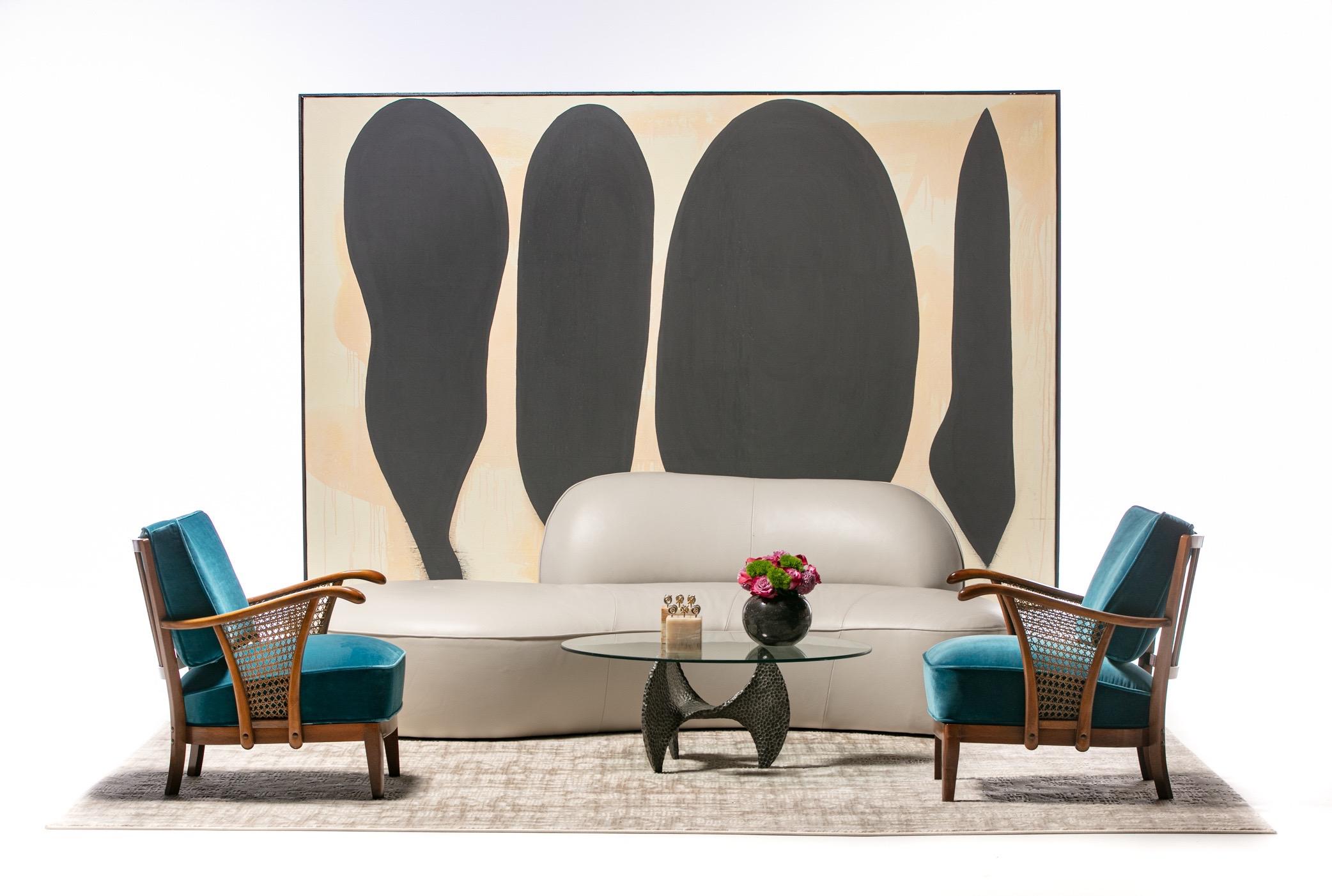 Pair of sculptural 1940s Scandinavian lounge chairs with cushions reupholstered in Lee Jofa blue velvet and cane panel arms. Attributed to Soren Hansen for Fritz Hansen. A luxe juxtaposition of materials with the velvet, cane and wood frames. Quite