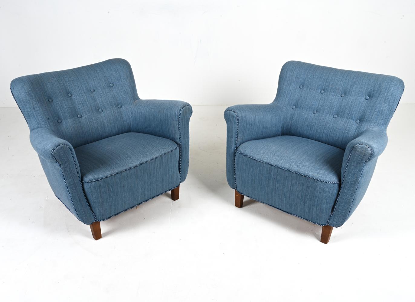 Channel the Danish art of coziness with this classic pair of easy chairs by a master Scandinavian furnituremaker. These chairs feature a classic silhouette which resembles that of the Model 1518 chair by Fritz Hansen or the 