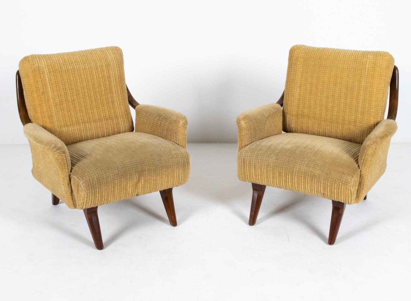 A fabulous pair of Danish mid-century lounge chairs with sculptural frames of stained beechwood, c. 1950's. With curves and angles inspired from the Atomic Age of design, these modern easy chairs are eye-catching statement pieces from every side.