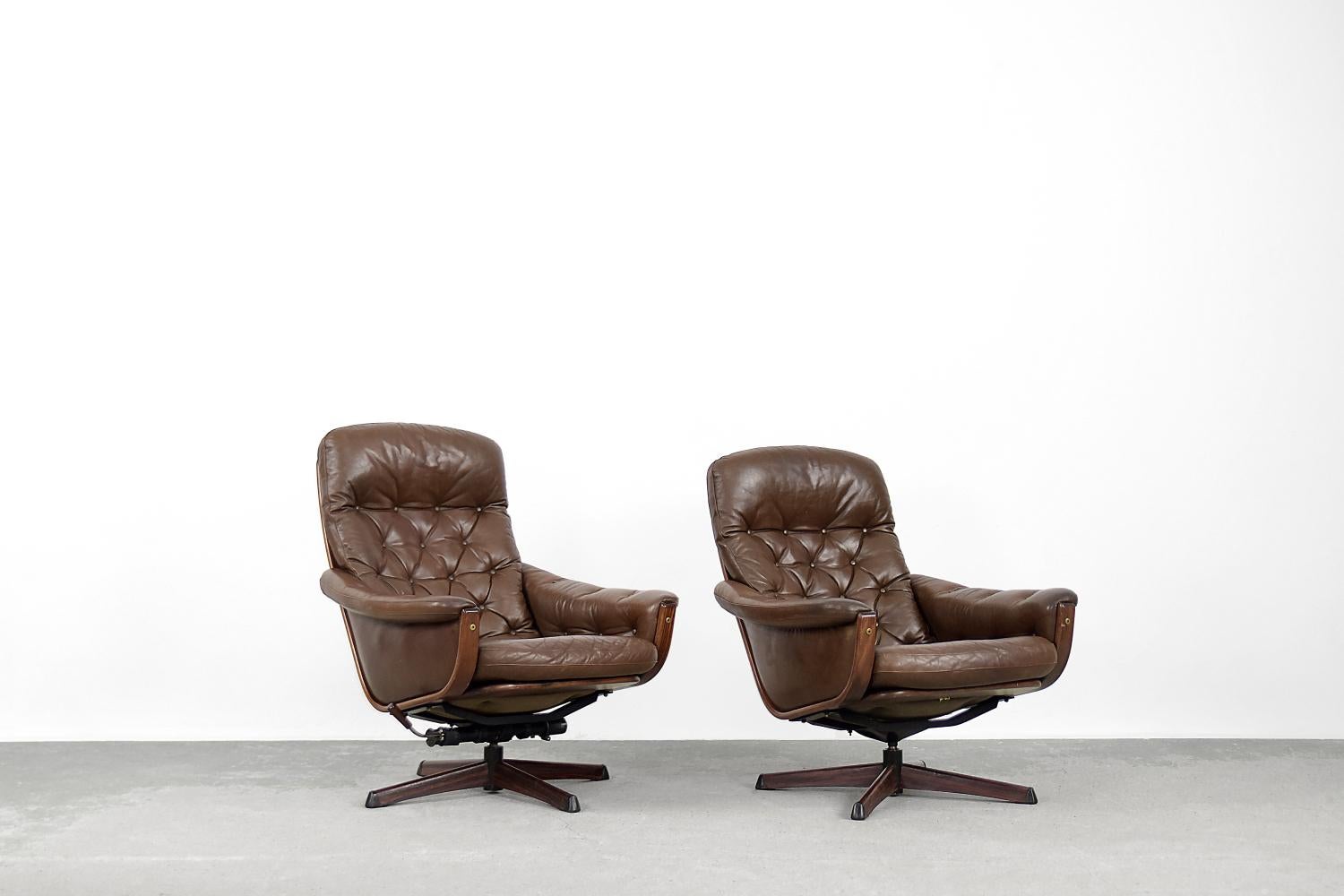This pair of modernist swivel armchairs was manufactured by the Göte Möbler in Sweden during the 1960s. The frame is made of solid wood, upholstered with brown natural leather with elegant quilting. The leg is made of metal and finished with veneer