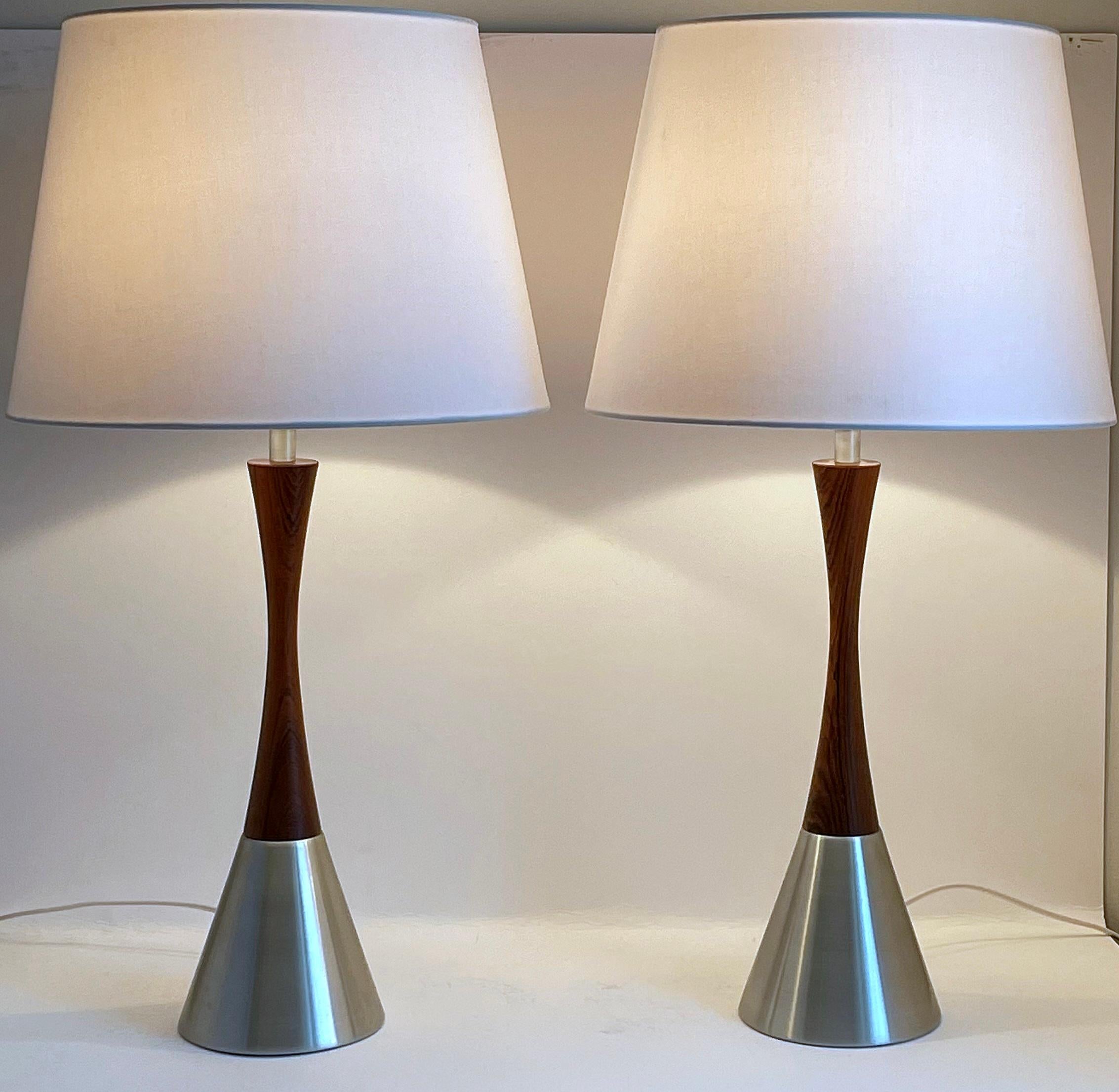 Set of two rare table lamps by Bergboms, Sweden 1960s. The lamps are made of walnut wood and brushed metal. The design is simple and elegant with the slim waist and the beautiful contrast between the wood and the metal. Very good vintage condition.