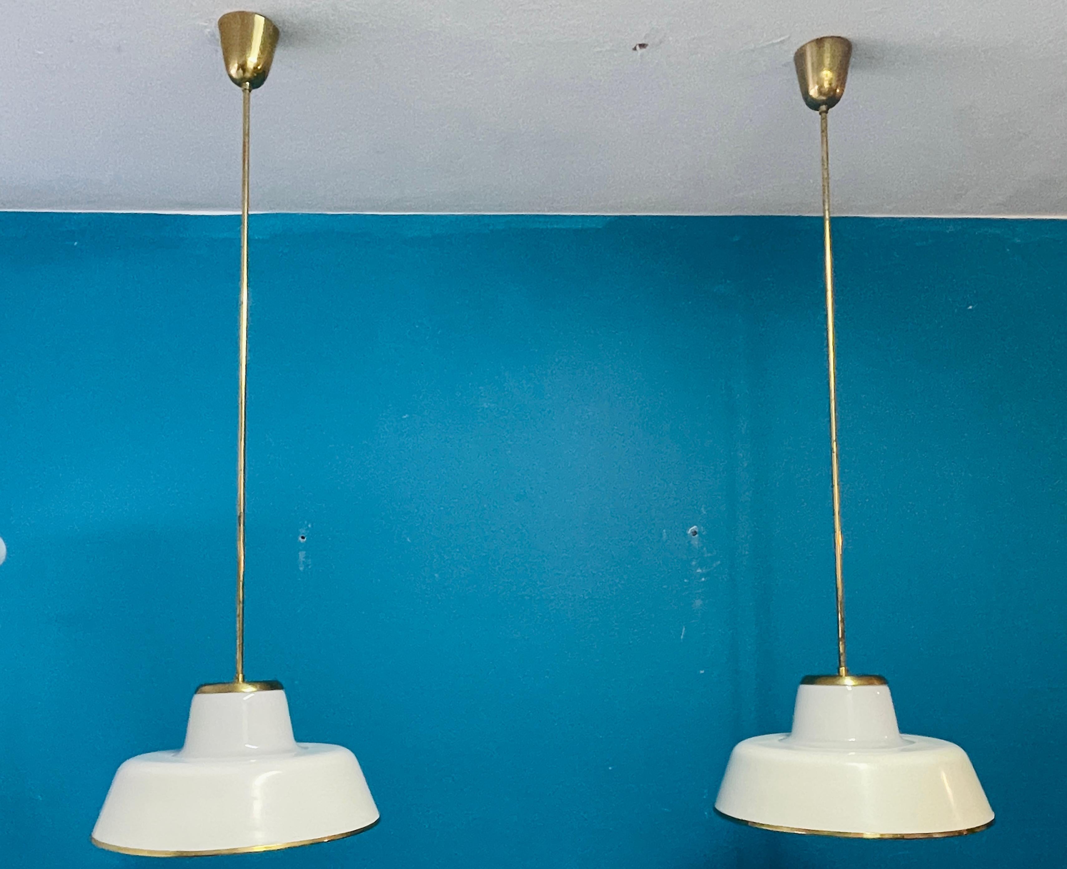 Una straordinaria coppia di lampade a sospensione Lisa Johansson-Pape modello 61-347, progettate negli anni '50 e prodotte da Orno. Questi apparecchi eccezionalmente alti raggiungono i 125 cm (49,2 pollici), rendendoli un'aggiunta rara e