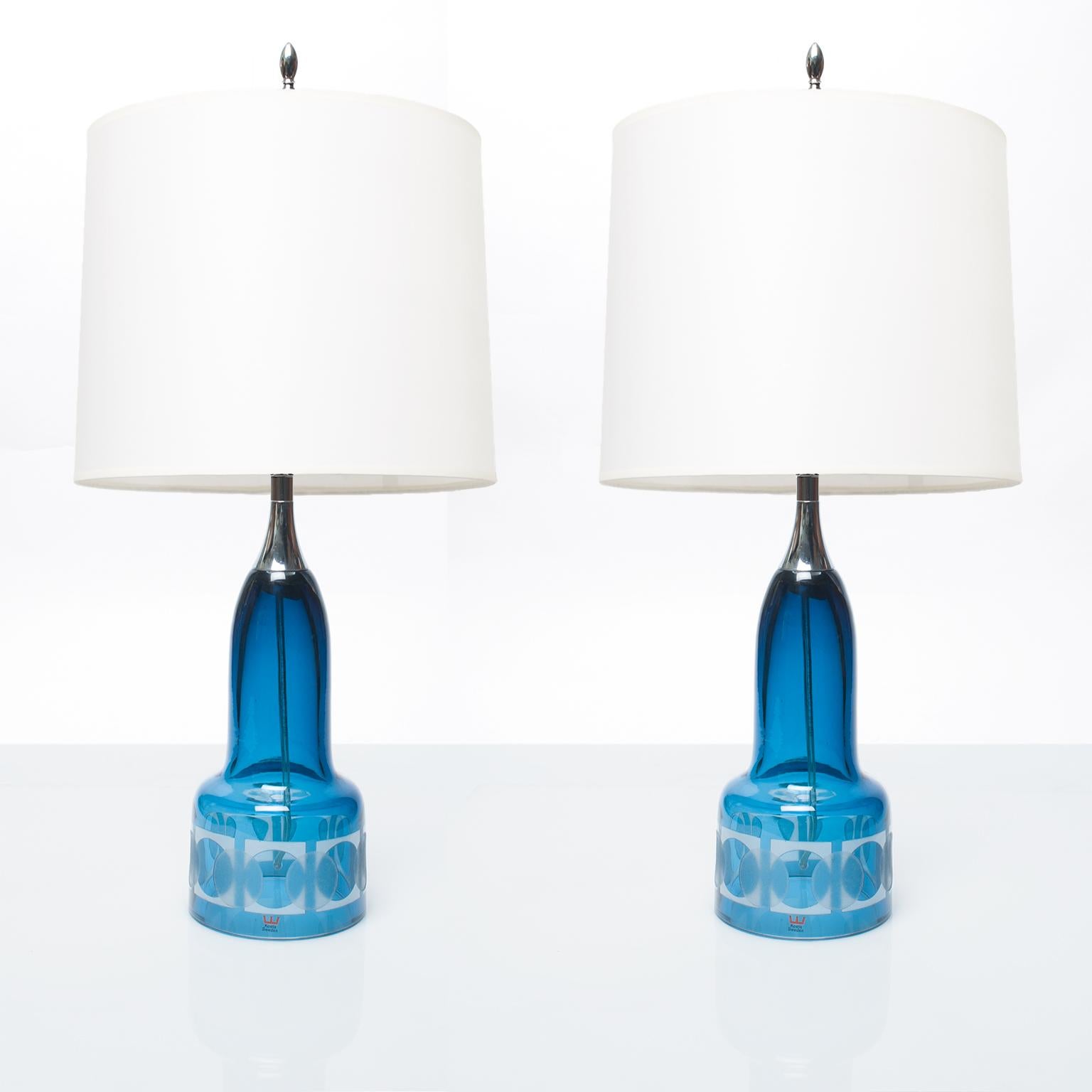 Pair of Scandinavian Modern hand blown, blue etched glass lamps with nickel plated hardware. Newly rewired for use in the USA with a single 3-way socket and cord switch. Designed by Owe Sandeberg for Kosta, Sweden circa 1960.
Shade not