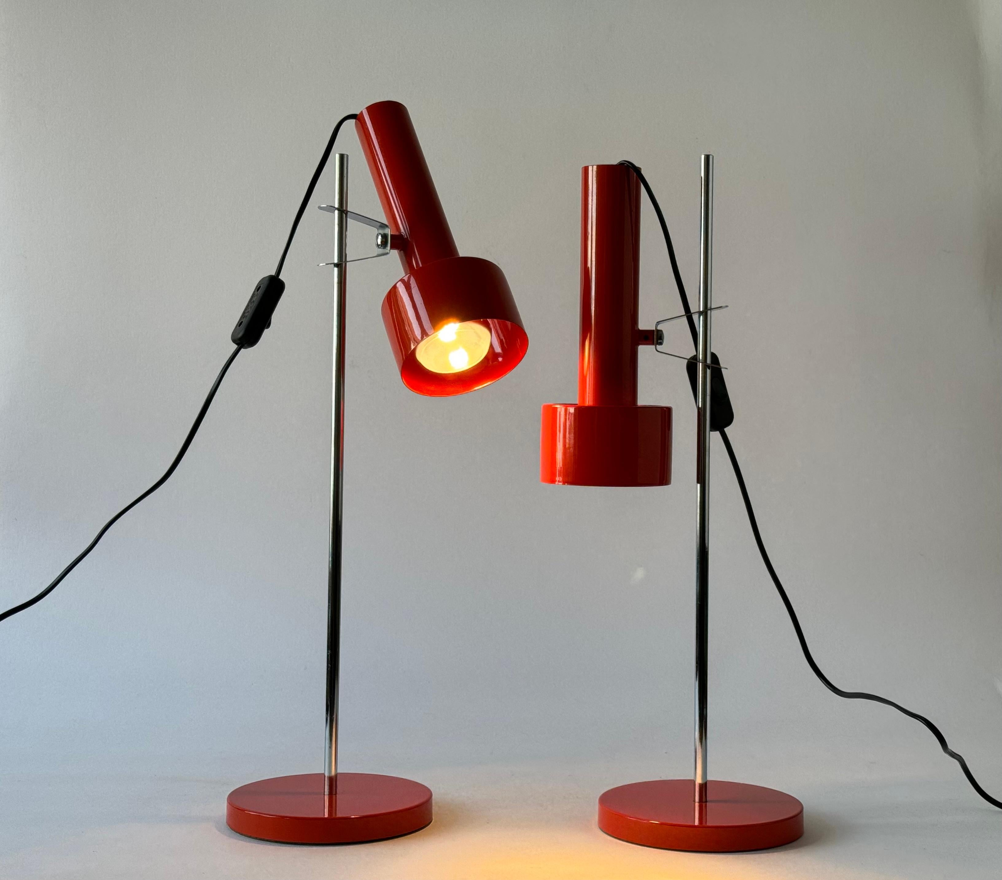 Pair of Mid-century Modern desk lamps made of metal. Made ca. 1970s.

The lamps come with the original orange lacquer. 
They are adjustable in all directions and can easily be slided up and down in height.

They have switchers on the wire.

Height