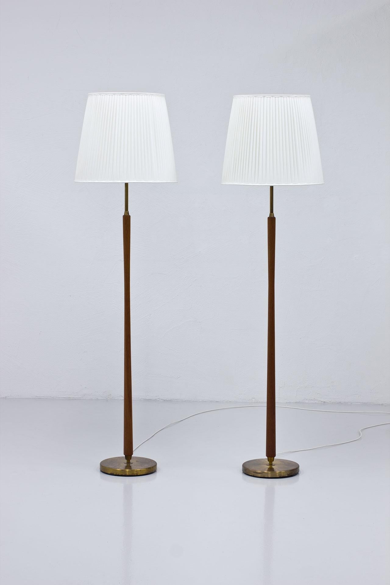 Pair of  floor lamps  manufactured  by
ASEA in Sweden during the 1940s-50s.
Made  from brass  with teak stem  with
new  hand  sewn  shades  in  off -white
chintz fabric.  Four light bulbs on each
lamp with two light switch. One uplight
source,  the 