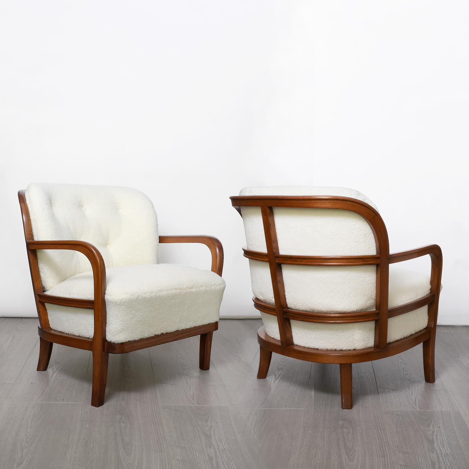 Pair of lounge chairs with “ribbed” frames in stained solid elm wood. Upholstered in faux lambs skin fabric. Newly restored in excellent condition, designed by Carl-Johan Boman circa 1940s, made by OY Boman, Finland.

Measures: Height 29“, width