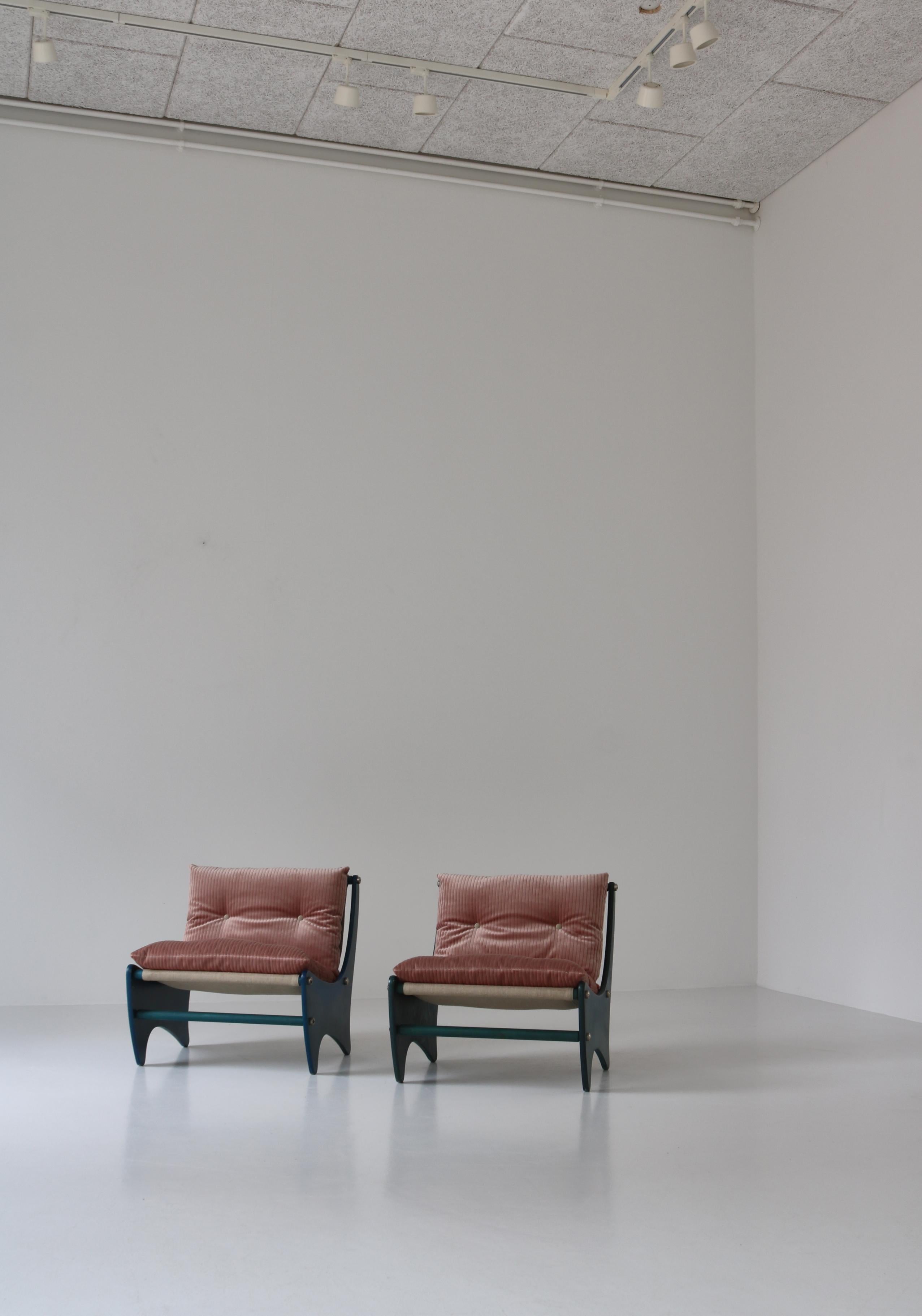 Charming pair of vintage lounge chairs made in Denmark in the 1960s. The chairs are made from blue stained plywood and the original cushions have been upholstered in pink velvet. The designer is not identified, but the organic space-age design looks