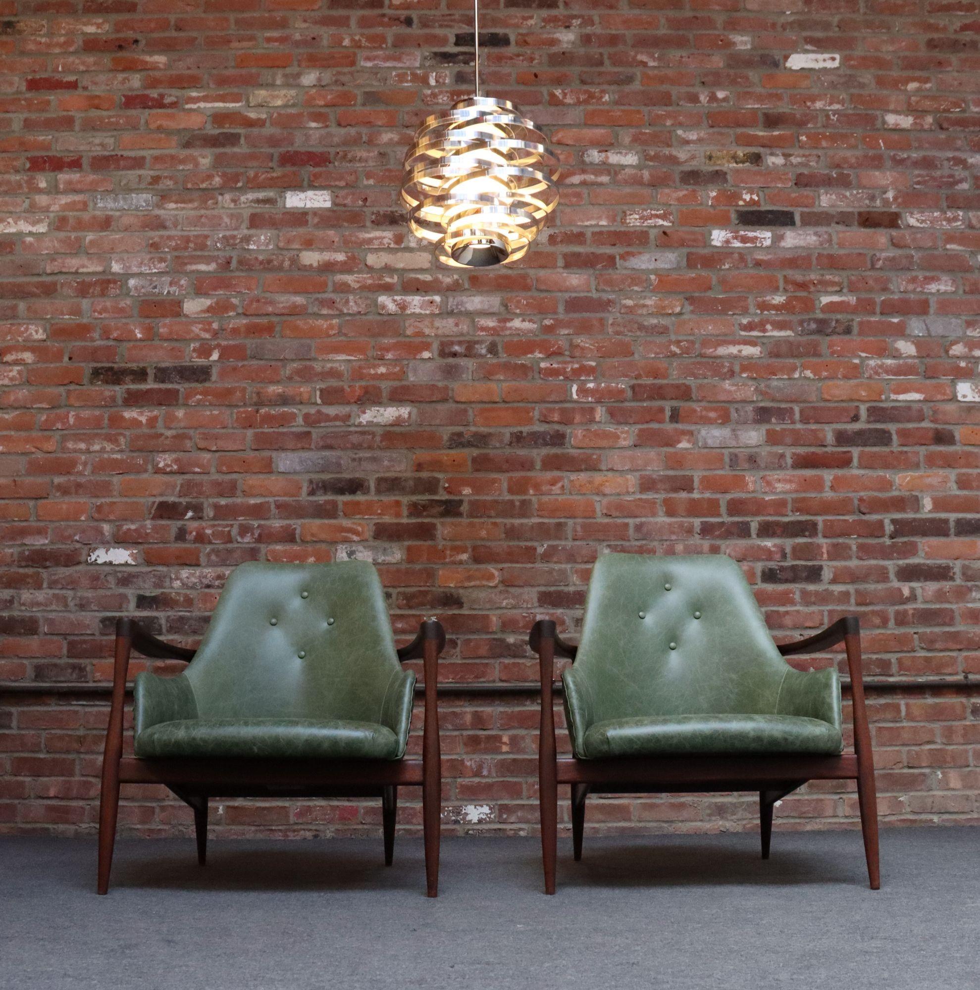 Coppia di piccole poltrone da salotto The Modern Scandinavian (1960 circa).
Composta da scultorei telai in noce che sostengono sedute compatte recentemente rivestite in pelle verde, con design distressed, con frontali con bottoni a motivo diamante e