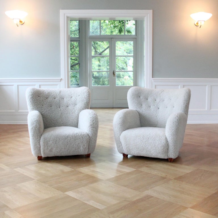 Scandinavian Modern, Denmark, 1950s.

A magnificent sculptural pair of Mid-Century Modern armchairs, Fritz Hansen, Denmark, 1950s.

The armchairs have been reconditioned with new upholstery in luxurious off-white shearling and dark brown leather
