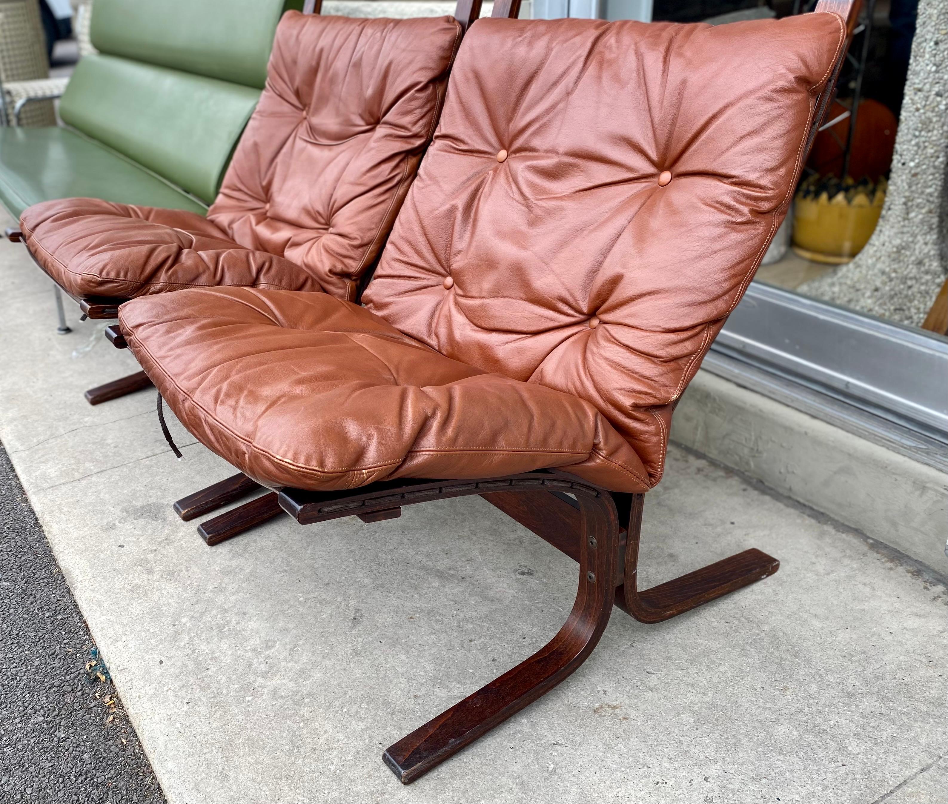 Scandinavian Modern Siesta Lounge Chairs by Westnofa was designed in the 1970s by Ingmar Relling a Norwegian designer. The wooden frame is made of bentwood with leather seating in a warm deep cognac color. These vintage lounge chairs are in great