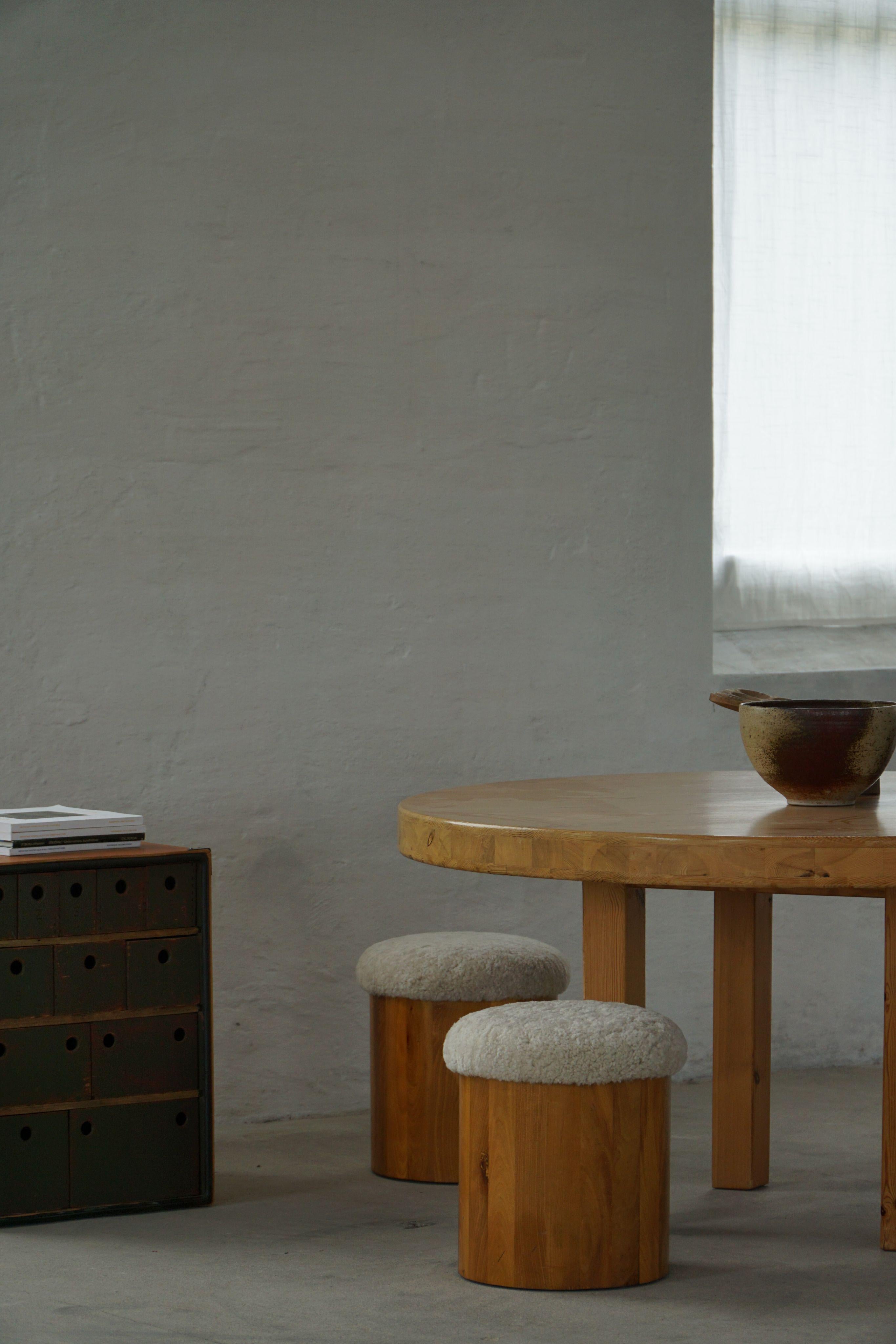 A beautiful pair of mid-20th-century stools featuring newly upholstered seats in soft, curly lambswool. Crafted with clean lines these stools have a minimalist aesthetic that highlights the beauty of the solid elm wood and mid-century design. The