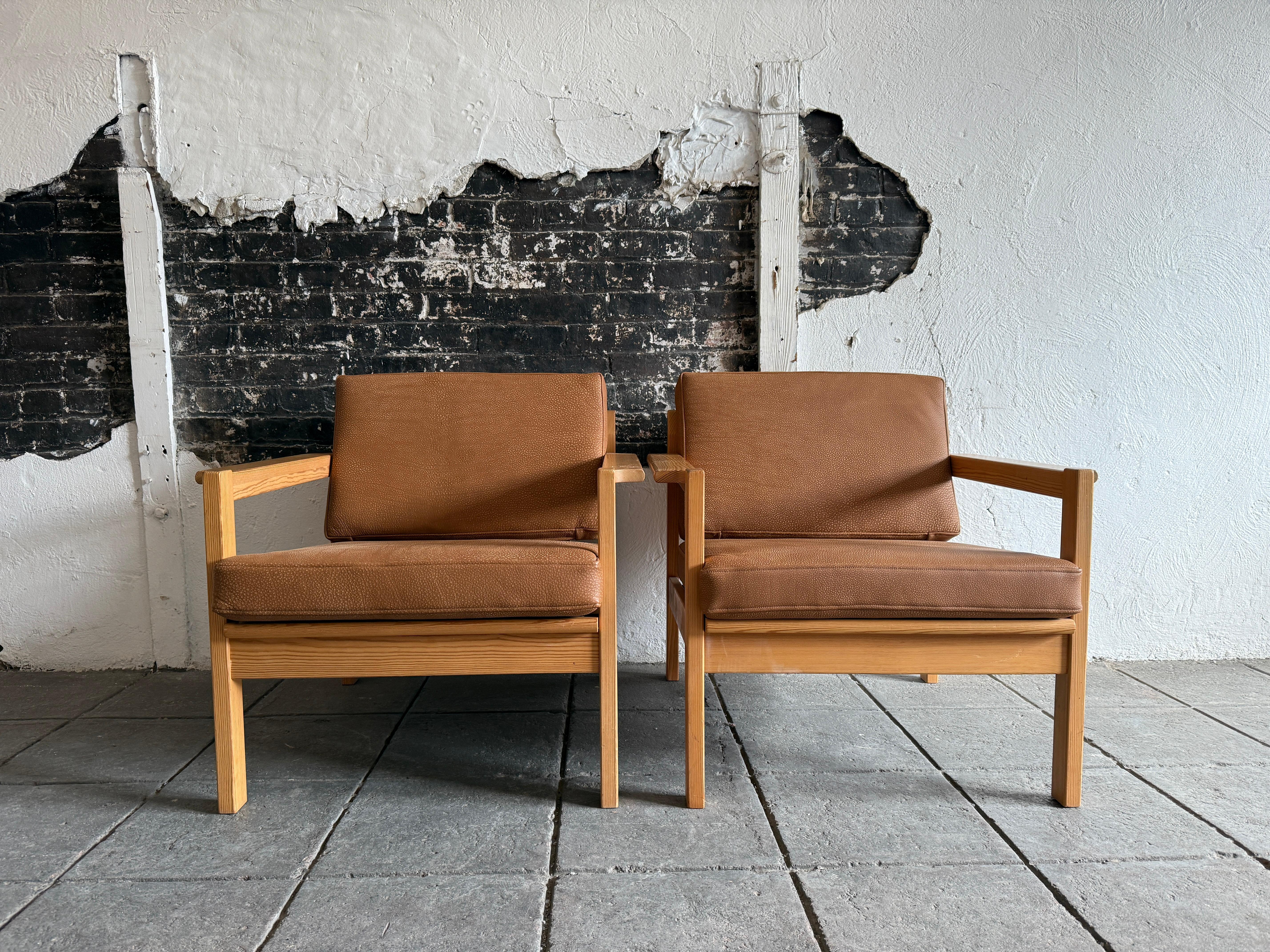 Coppia di poltroncine svedesi originali e rare, tutte bionde, in pino scandinavo, con rivestimento in pelle morbida marrone chiaro. Disegnato da Svein Bjørneng. Struttura in legno massiccio di betulla con schienale a doghe e rivestimento in pelle,