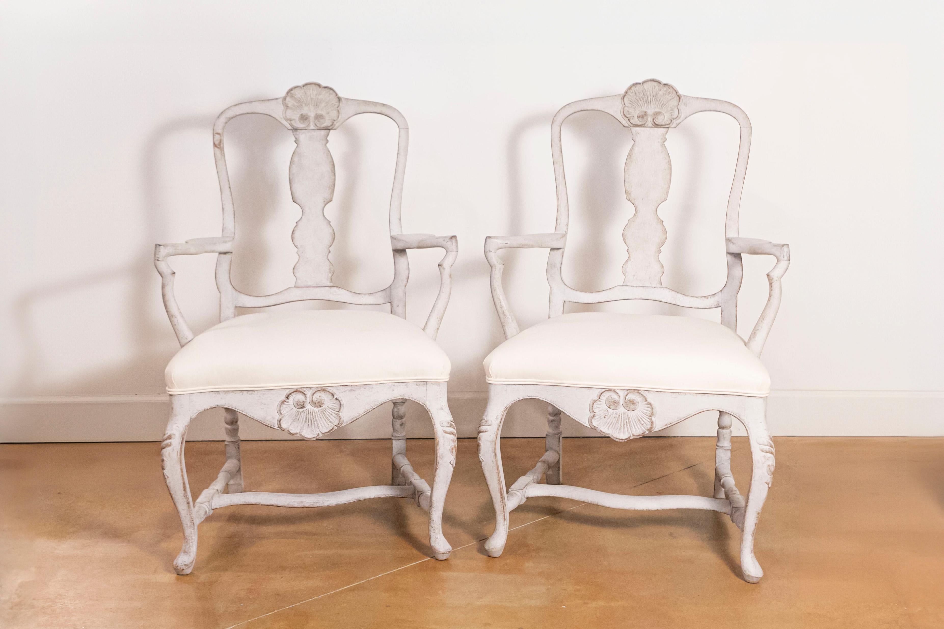 Paire de fauteuils scandinaves de style rococo du 19ème siècle avec une nouvelle tapisserie. Née en Scandinavie au cours du XIXe siècle, cette paire de fauteuils de style rococo se caractérise par un dosseret façonné surmonté d'une coquille